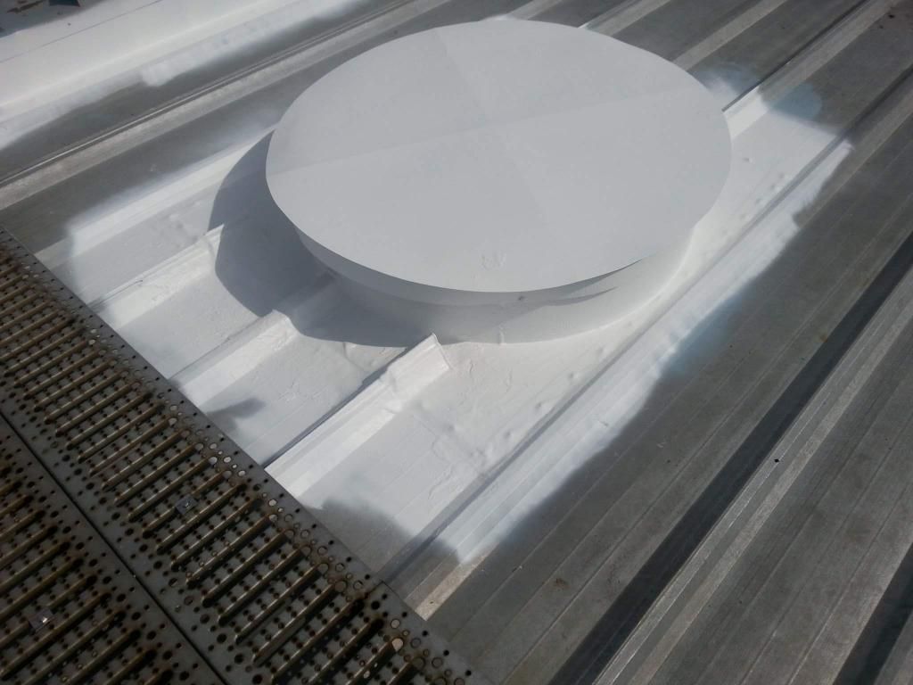 A white circular object is sitting on top of a metal roof