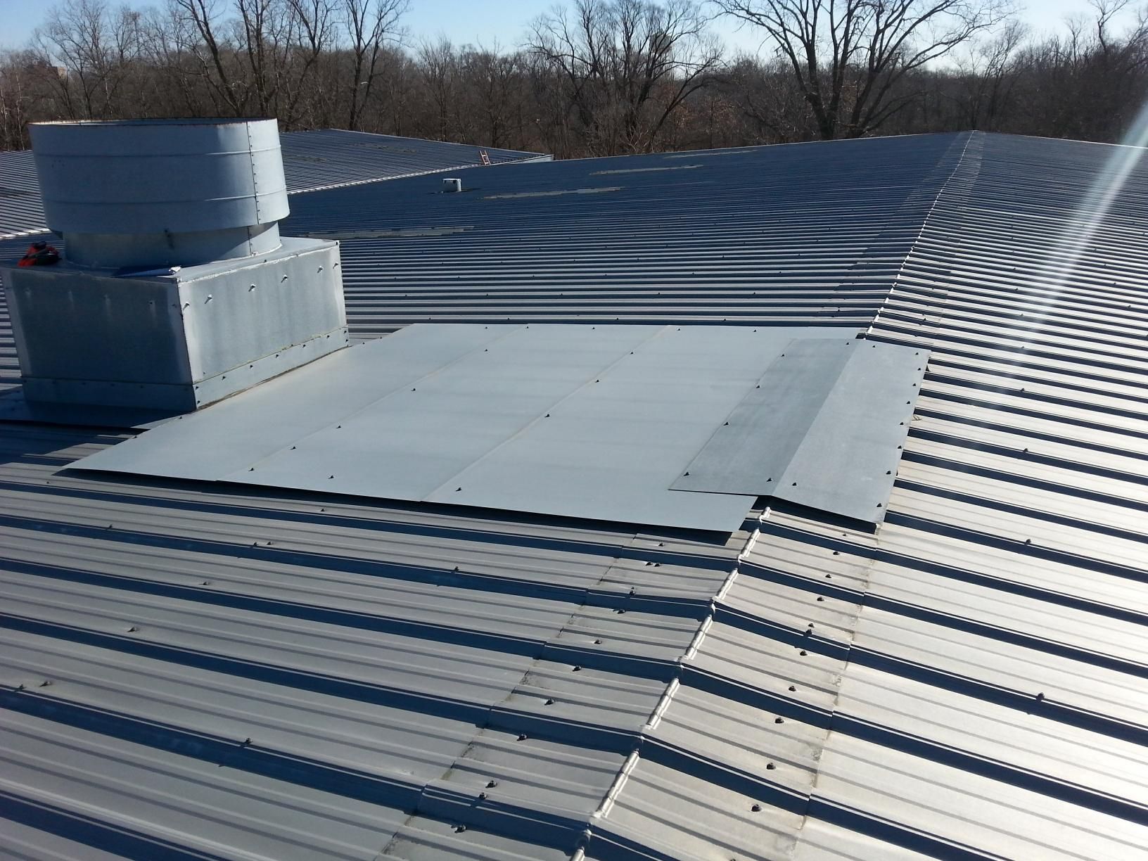 A metal roof with a chimney on top of it