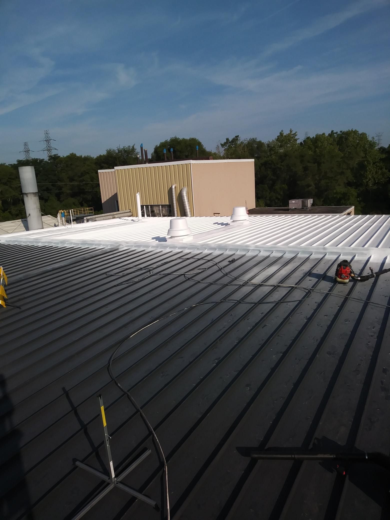 A roof with a lot of lines on it and a building in the background.