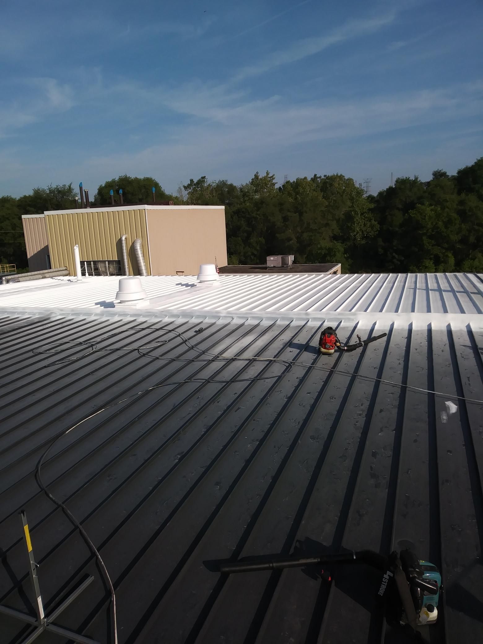 The roof of a building is being painted white.