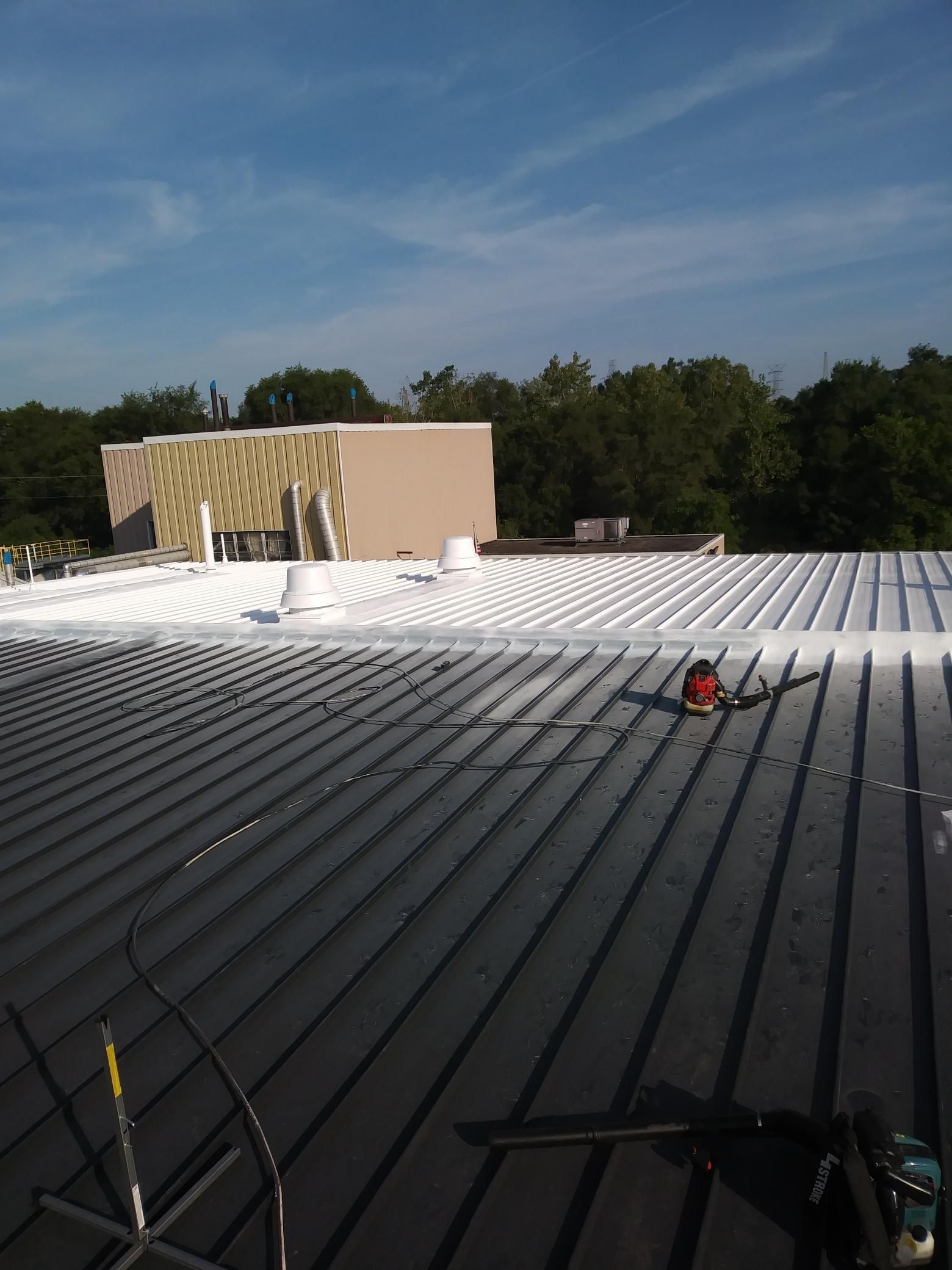 The roof of a building is being painted white