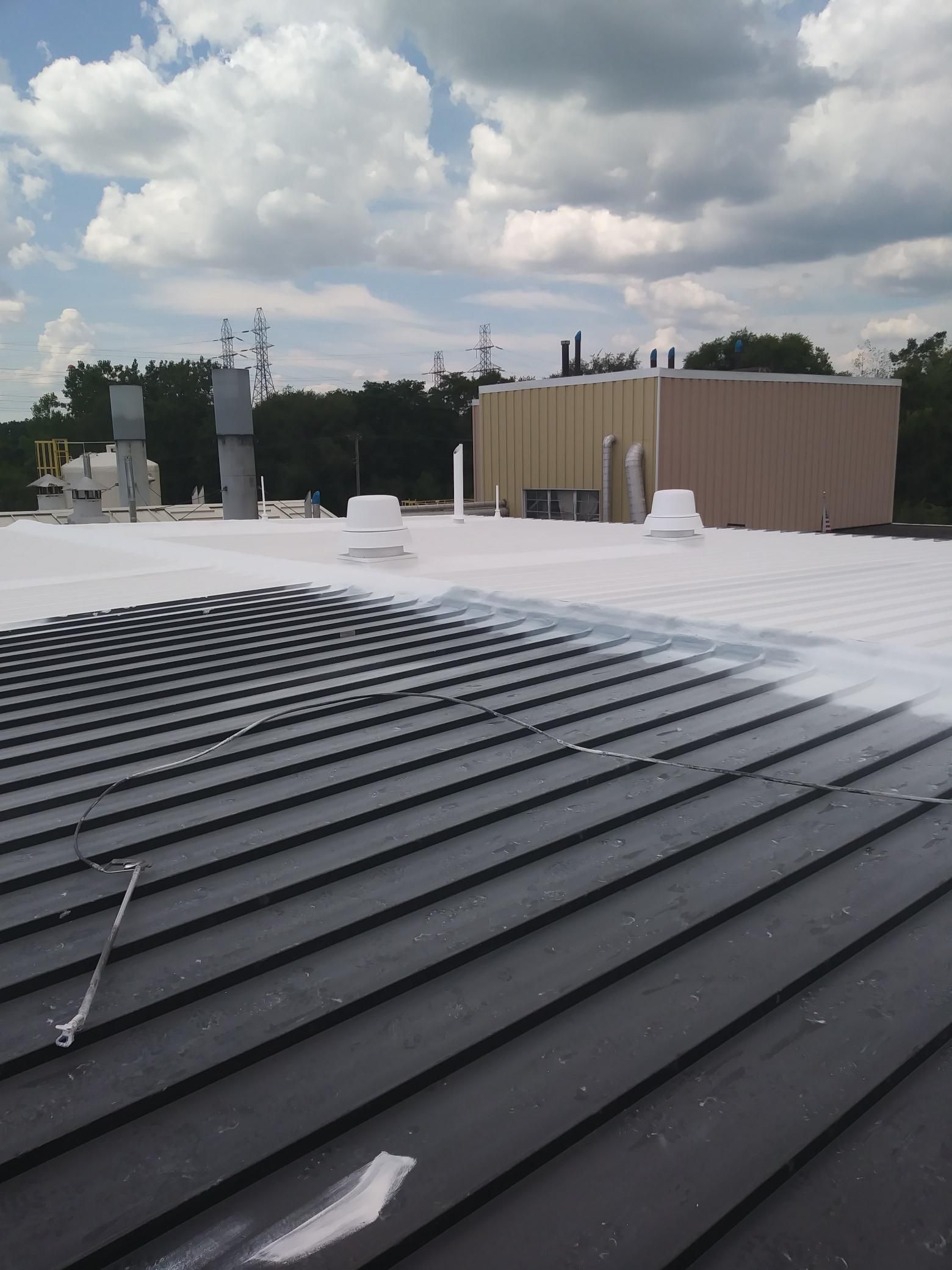 The roof of a building is being painted white