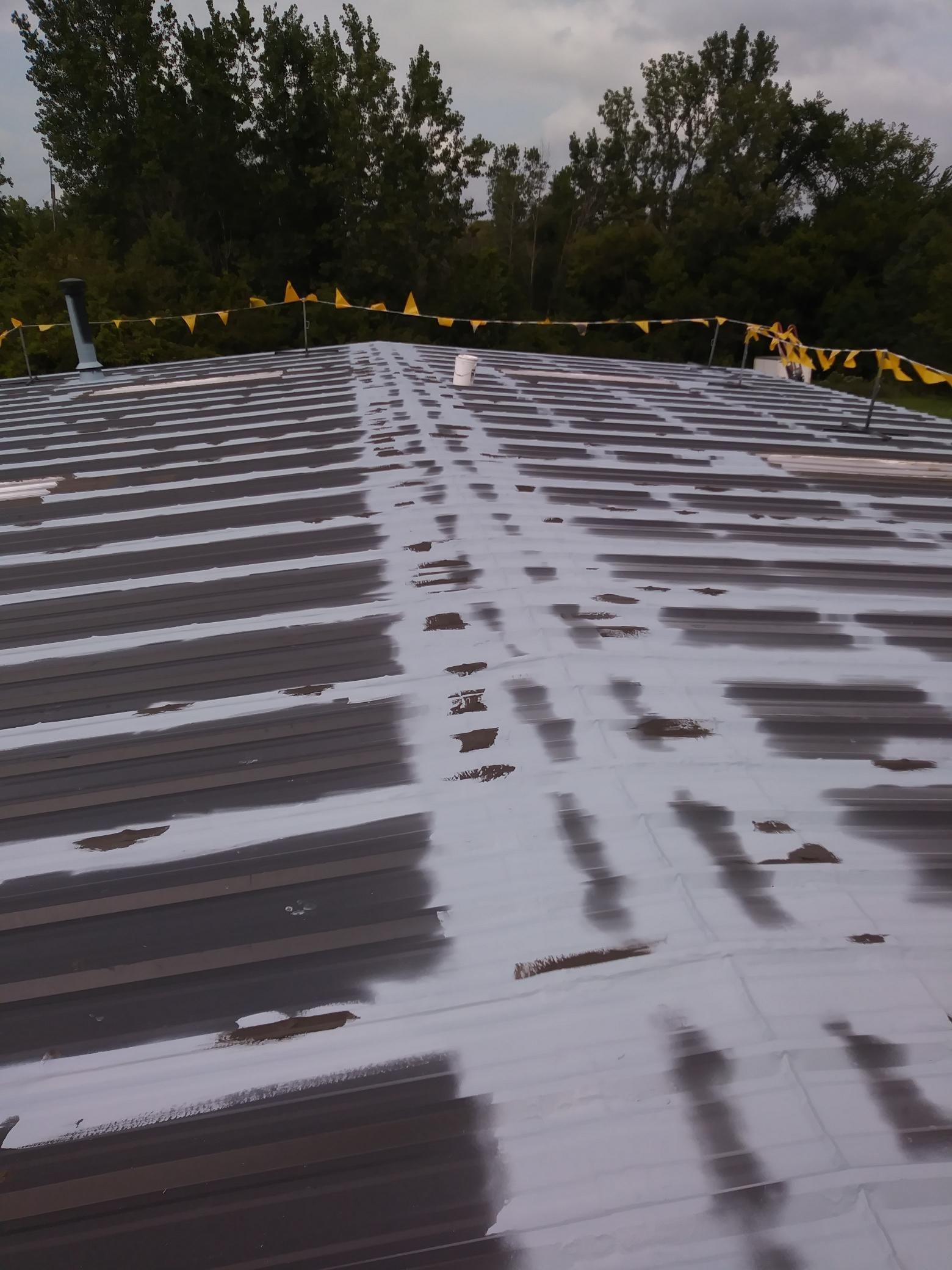 A roof with a lot of lines and trees in the background