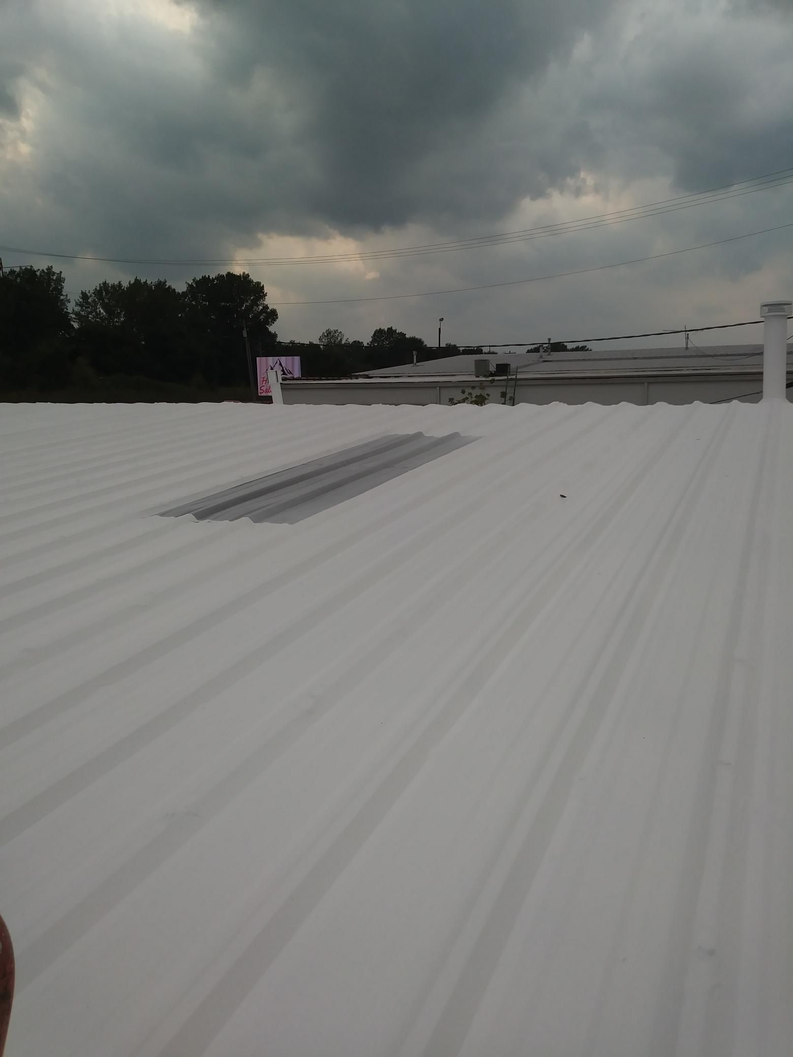 A white roof with a cloudy sky in the background