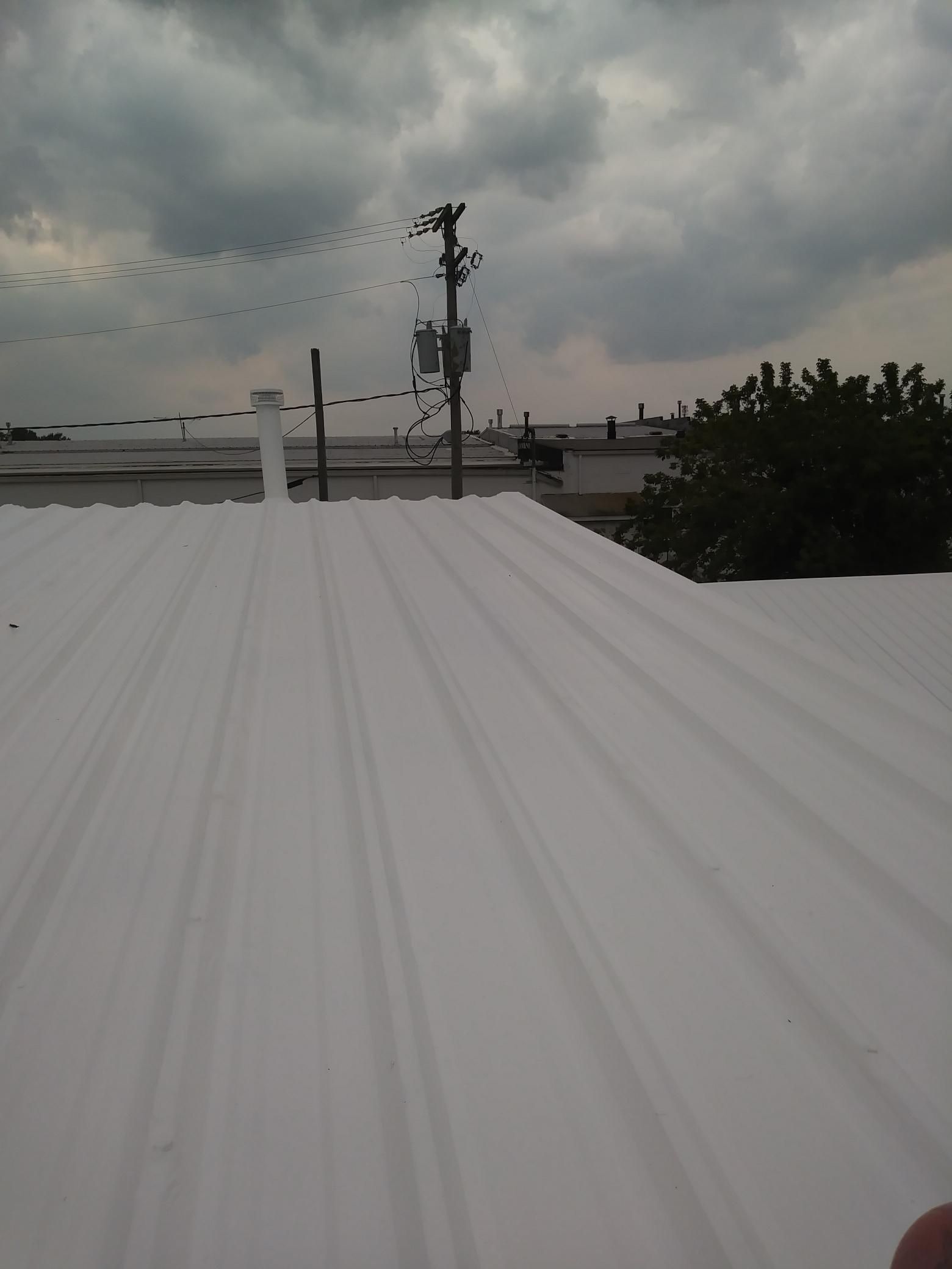 A white roof with a cloudy sky in the background