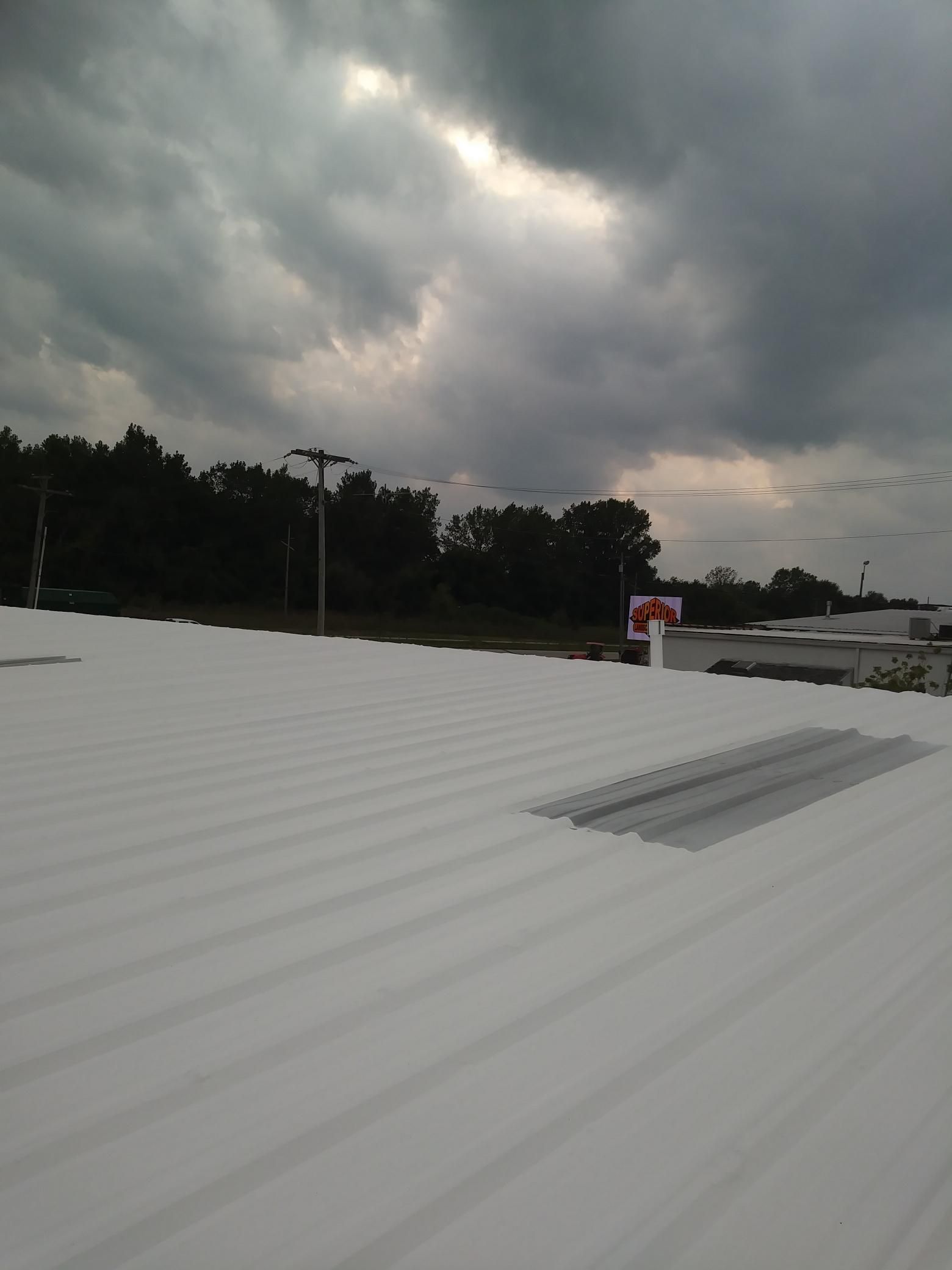 A white roof with a cloudy sky in the background