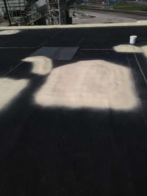 A pile of sand is sitting on top of a black roof.