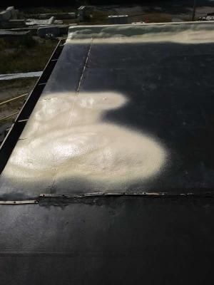 A close up of a black roof with foam on it.