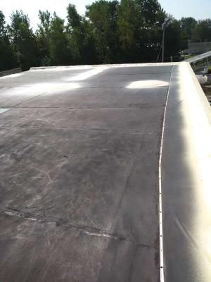 A close up of a roof with trees in the background.