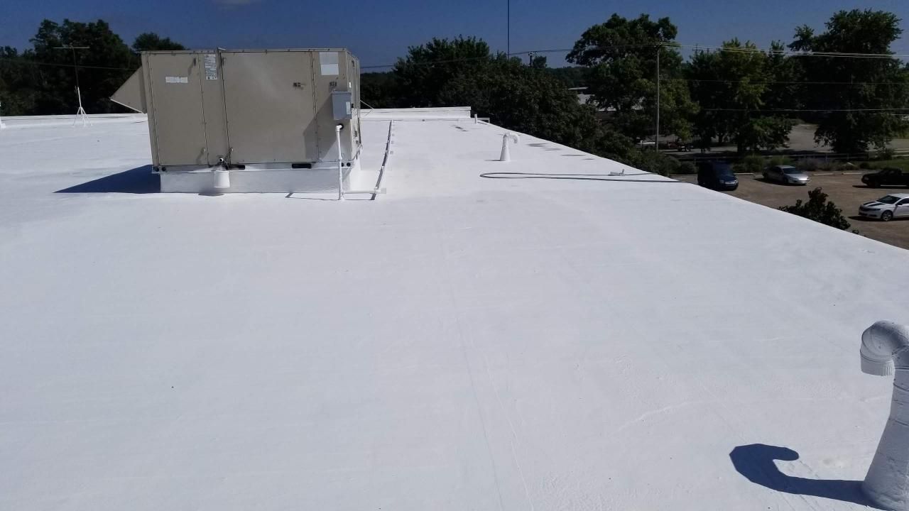 A white roof with a large air conditioner on top of it.