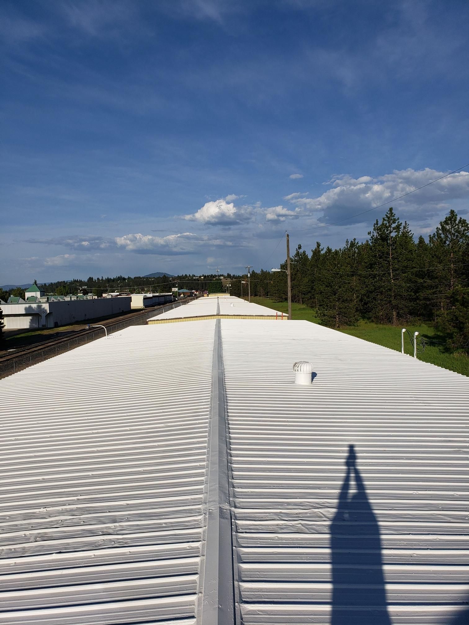A shadow of a person is cast on the roof of a building.