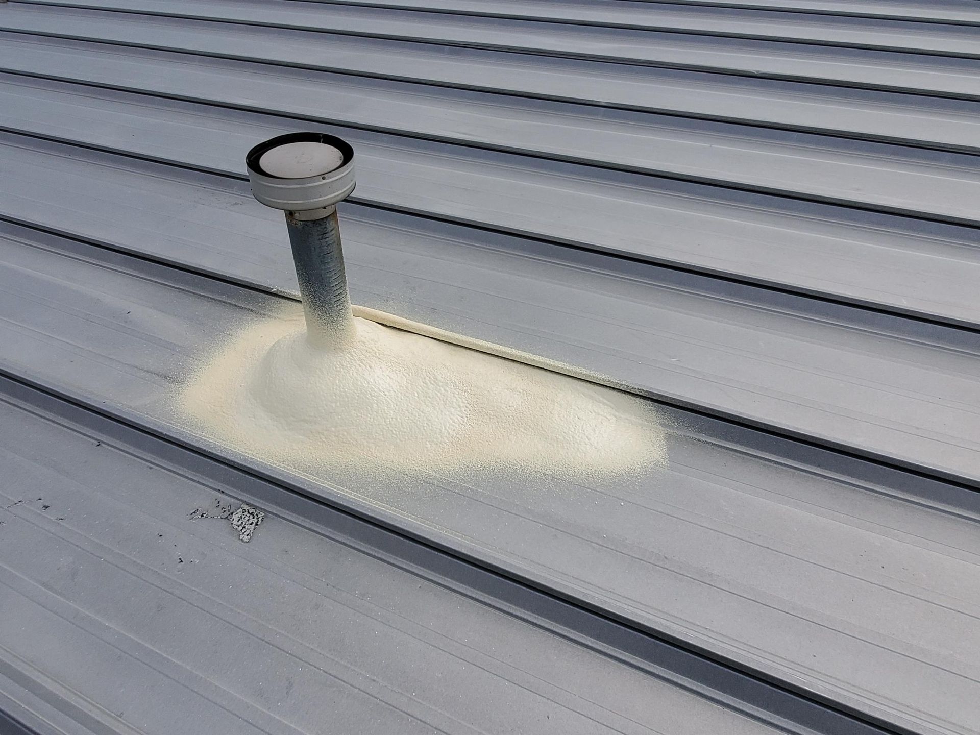 A roof with a pipe on it and a hole in it.