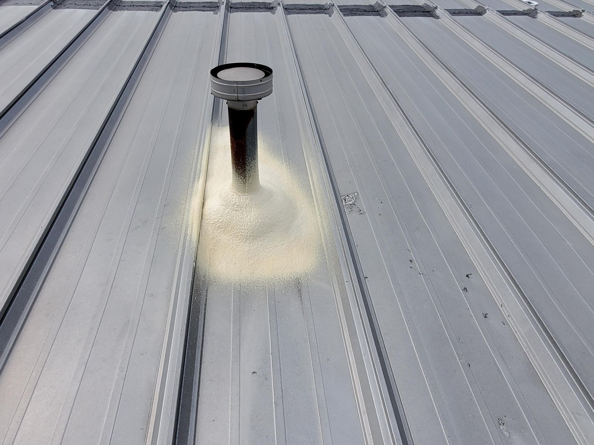 A metal roof with a chimney on top of it