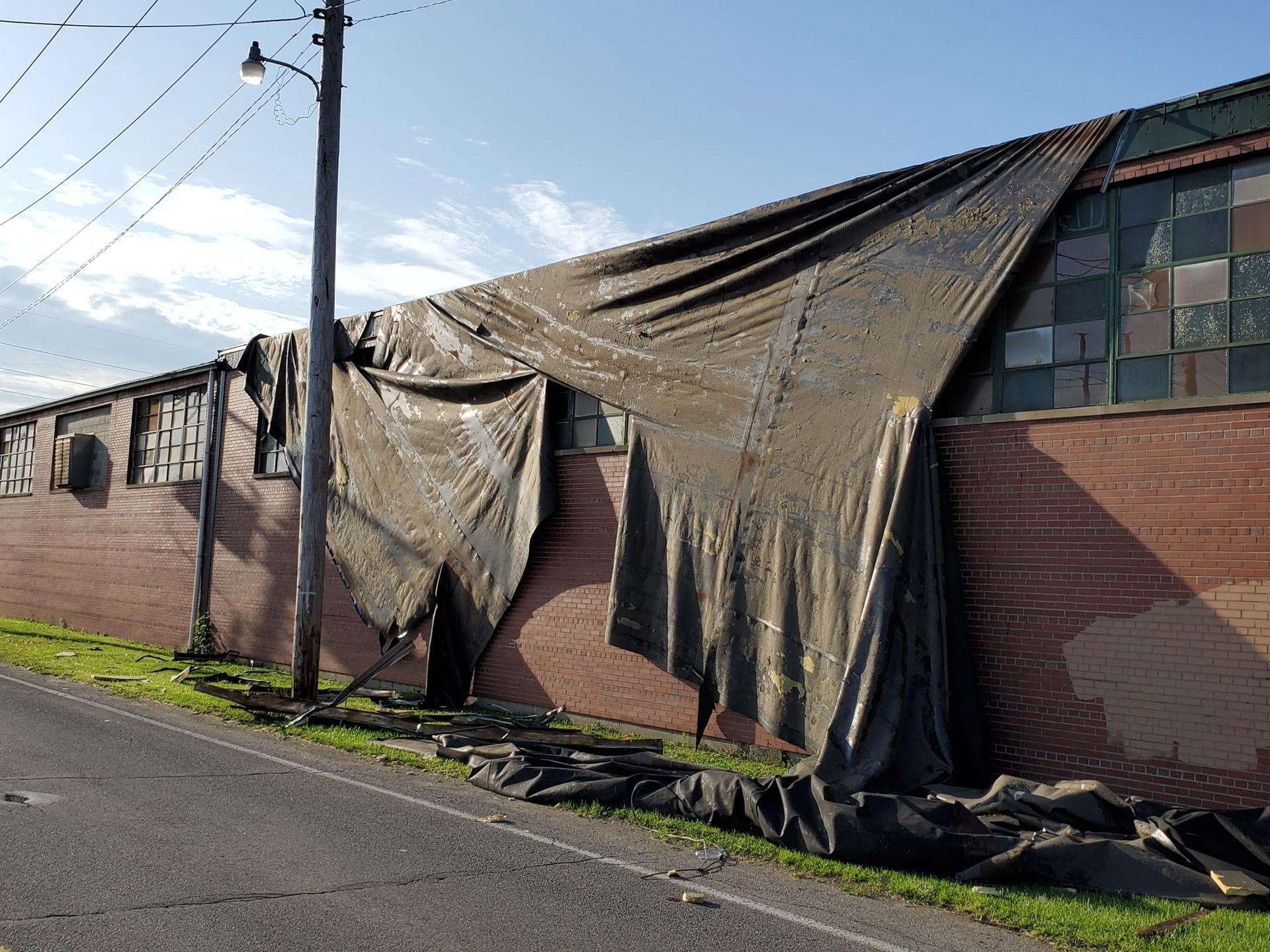 A brick building with a tarp on the side of it
