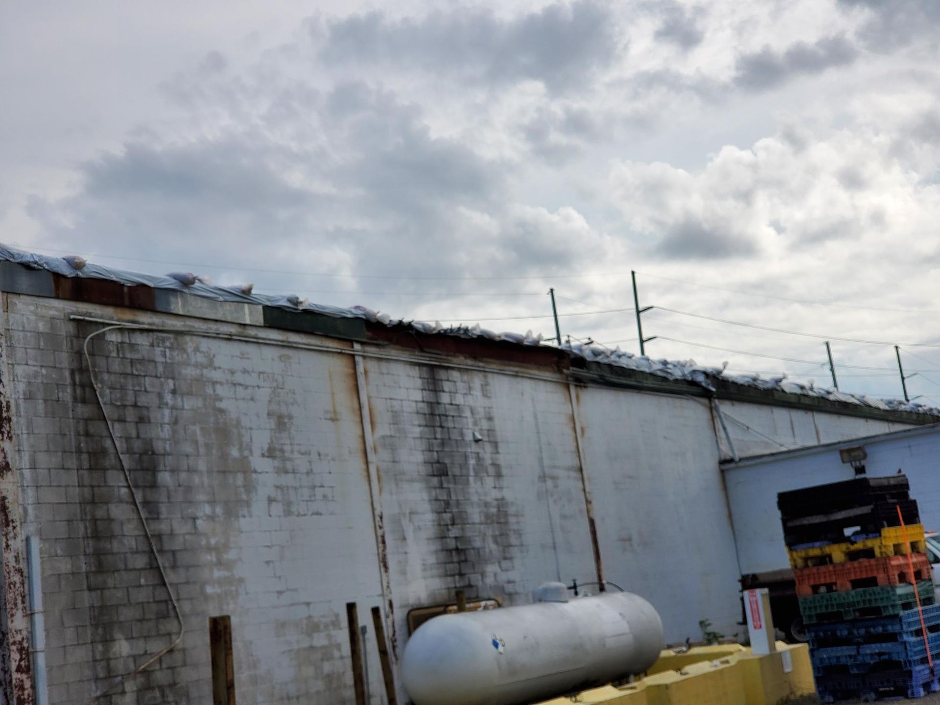 A large propane tank is sitting on the side of a building.
