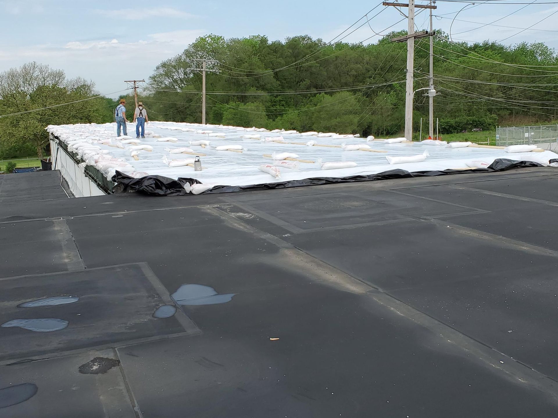 Two men are standing on the roof of a building.