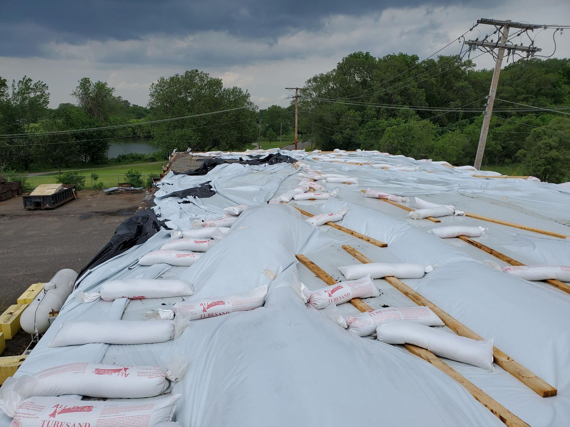 A roof with a lot of bags on it and trees in the background
