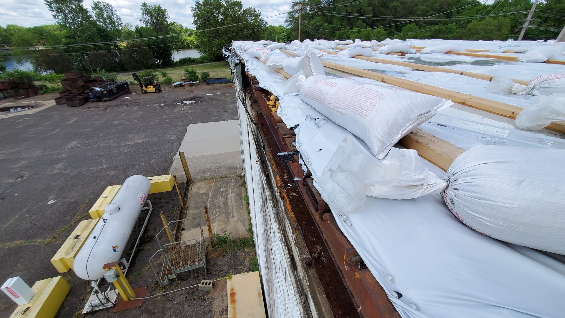 A roof with a lot of bags on it is being repaired.