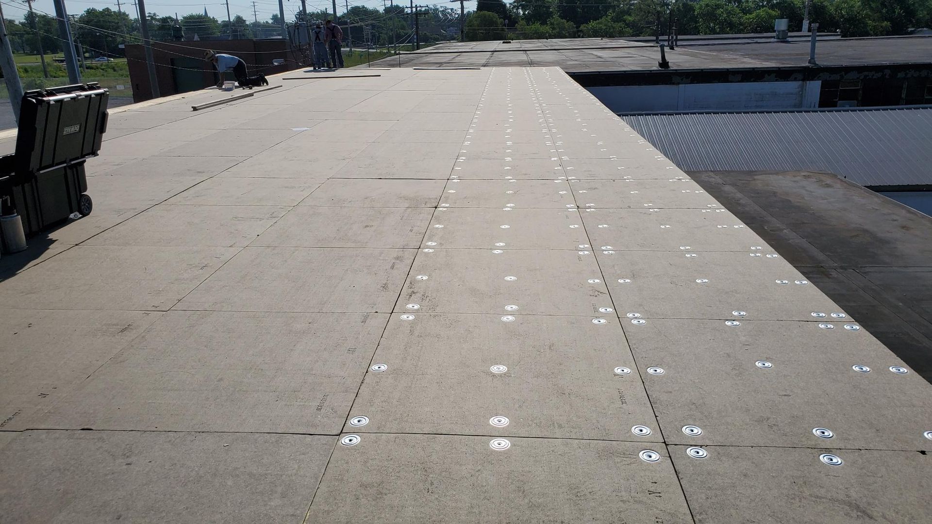 A roof with a lot of holes in it is being repaired.