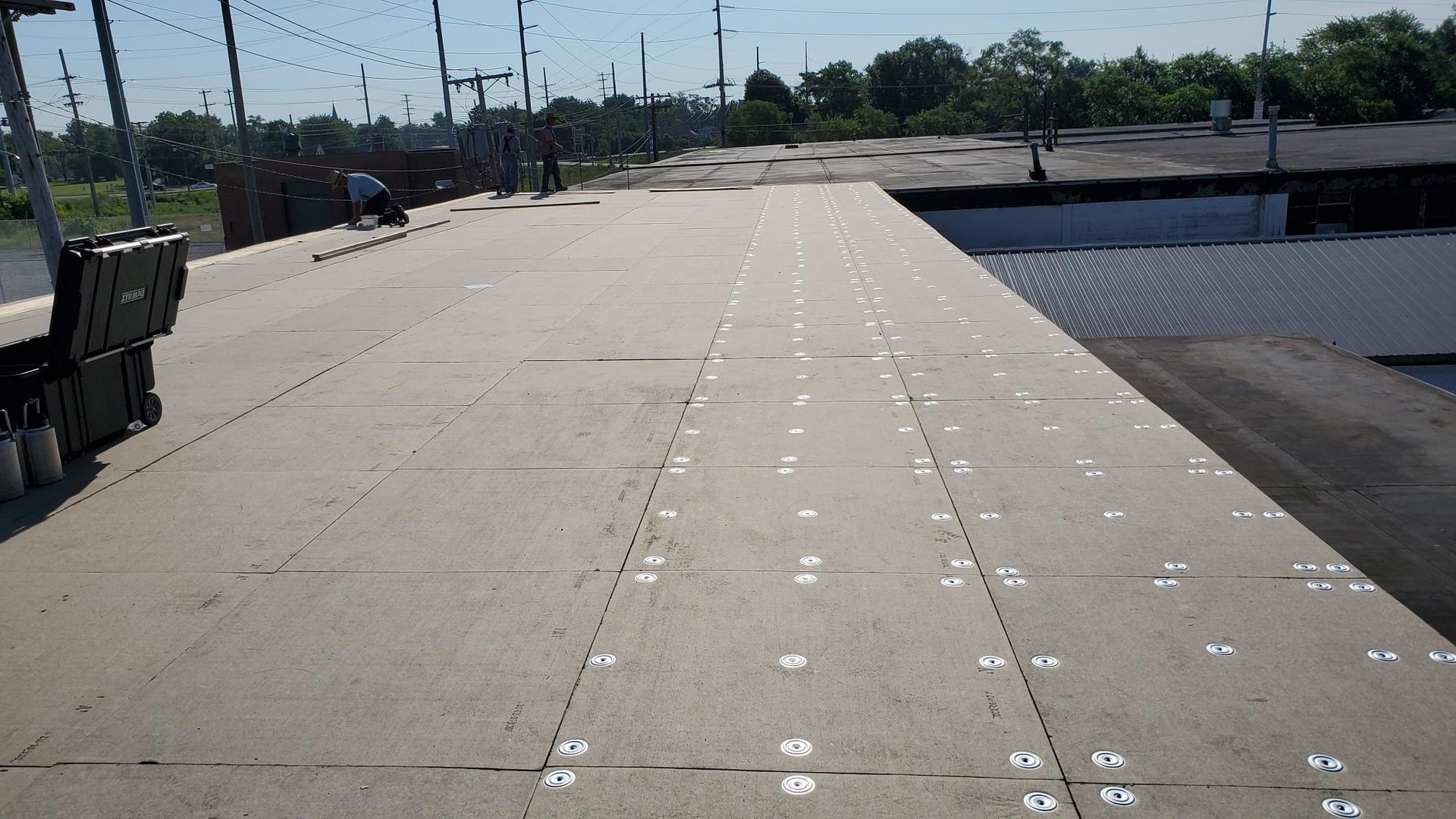 A roof with a lot of holes in it is being repaired.