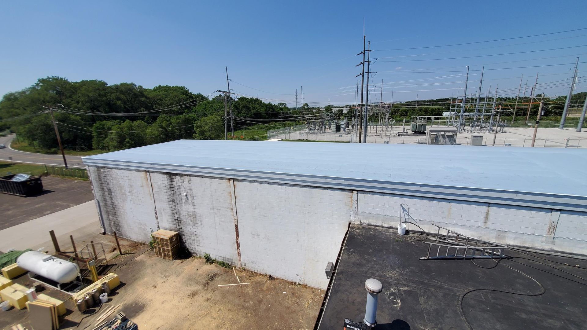 An aerial view of a building with a white roof and a black roof.