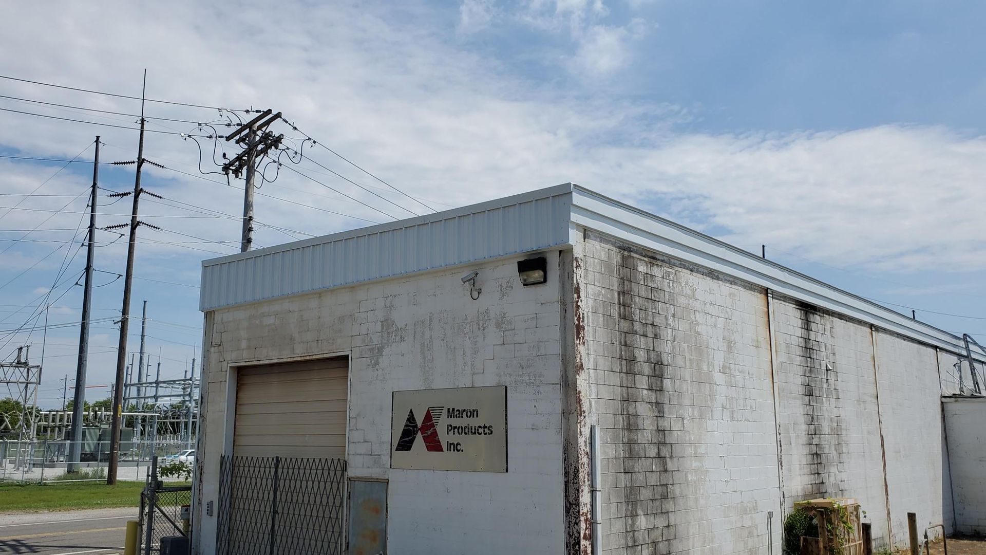 A white building with a sign that says jc on it