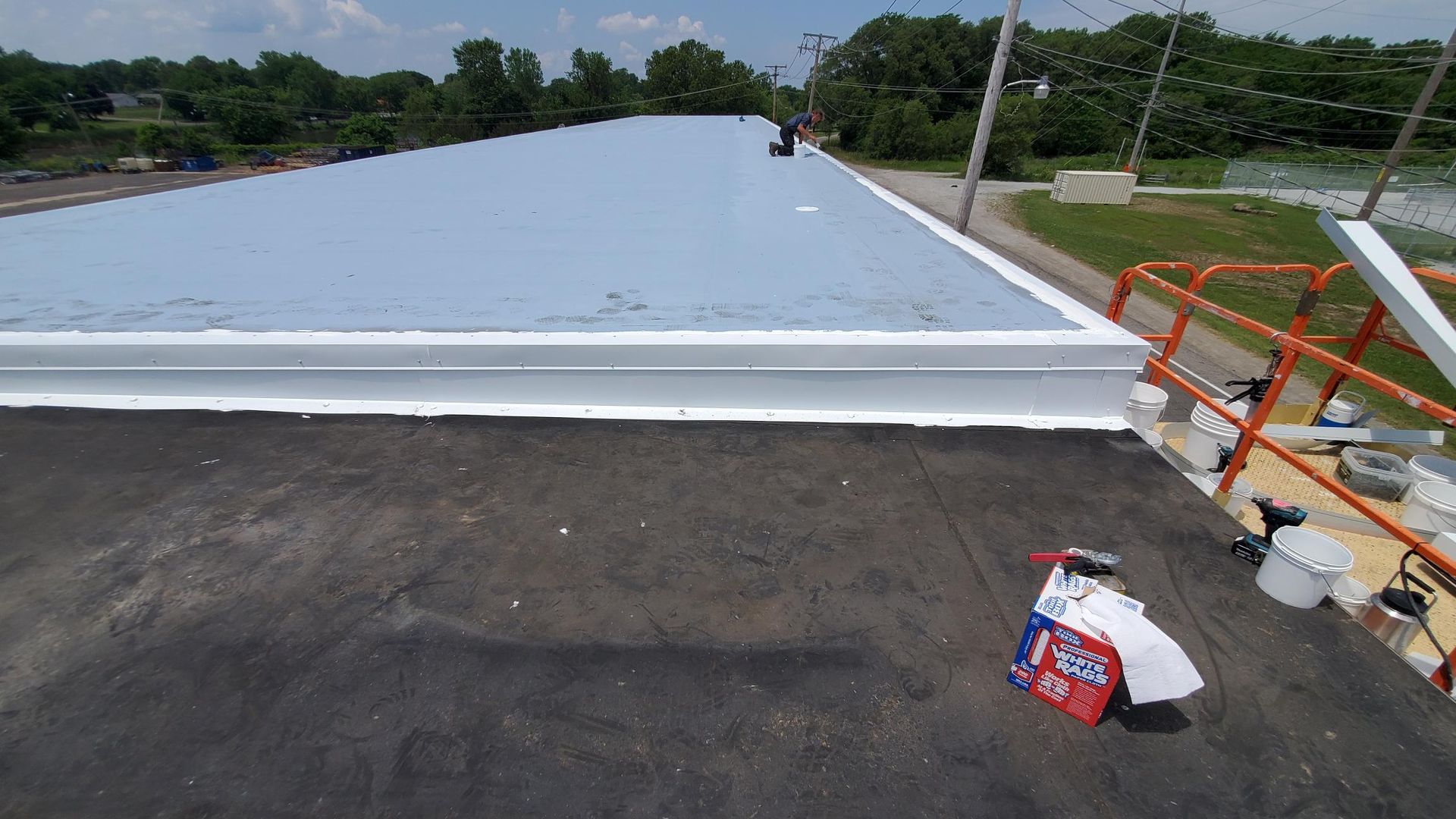 A roof with a white trim is being painted.