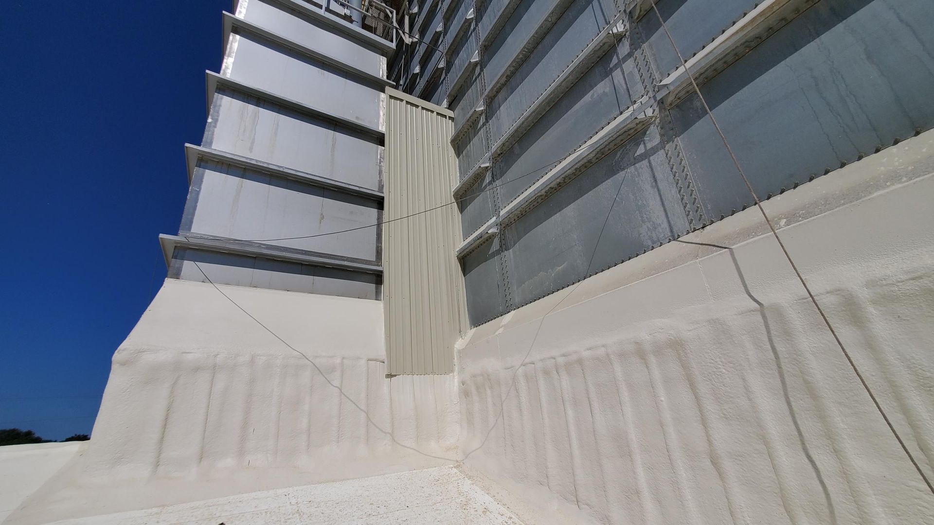 A large white building with a blue sky in the background.