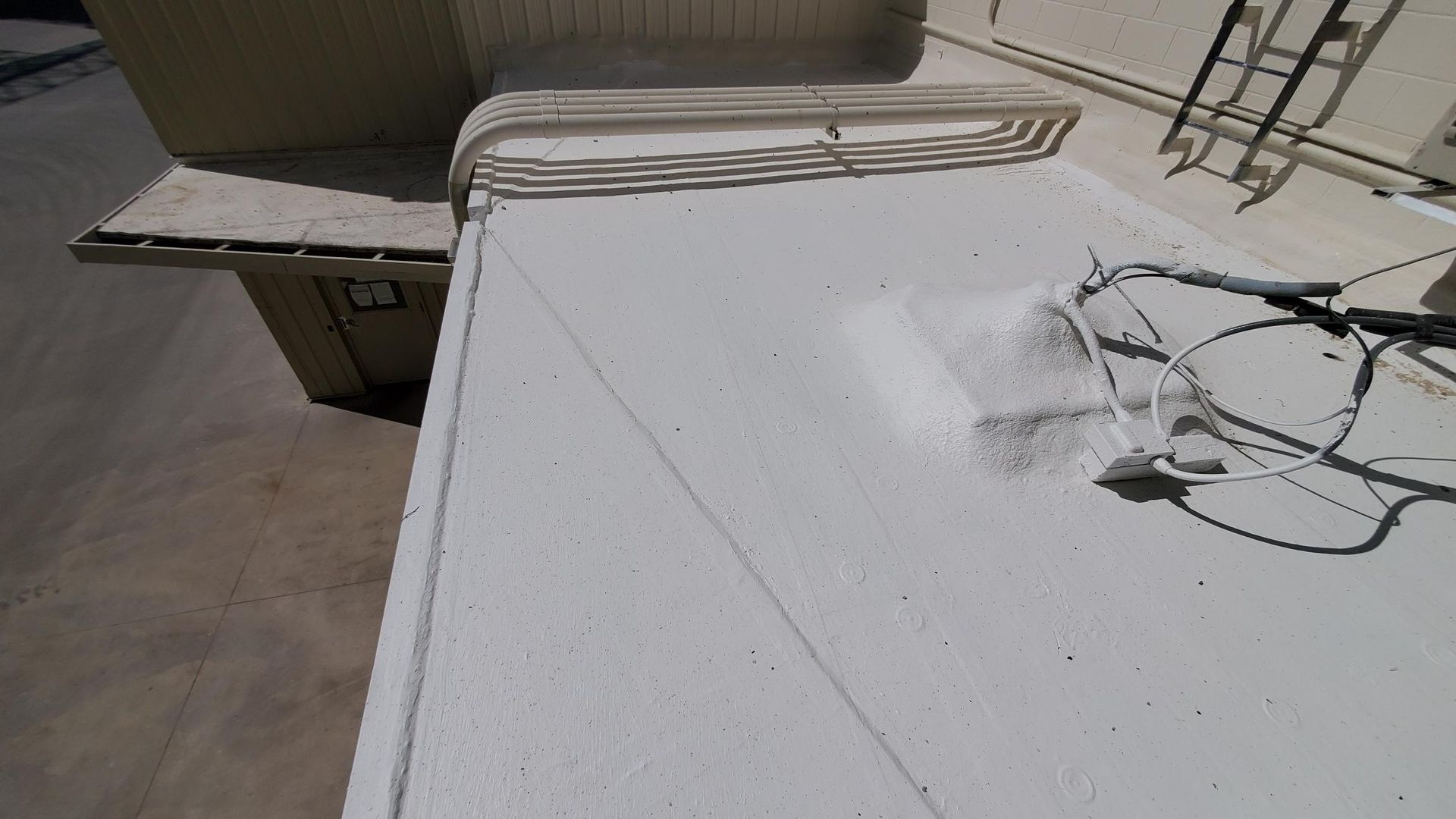 A white roof with a ladder on the side of it.