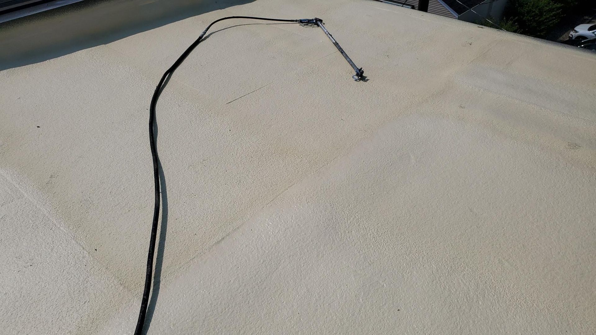 A black wire is laying on top of a white surface.