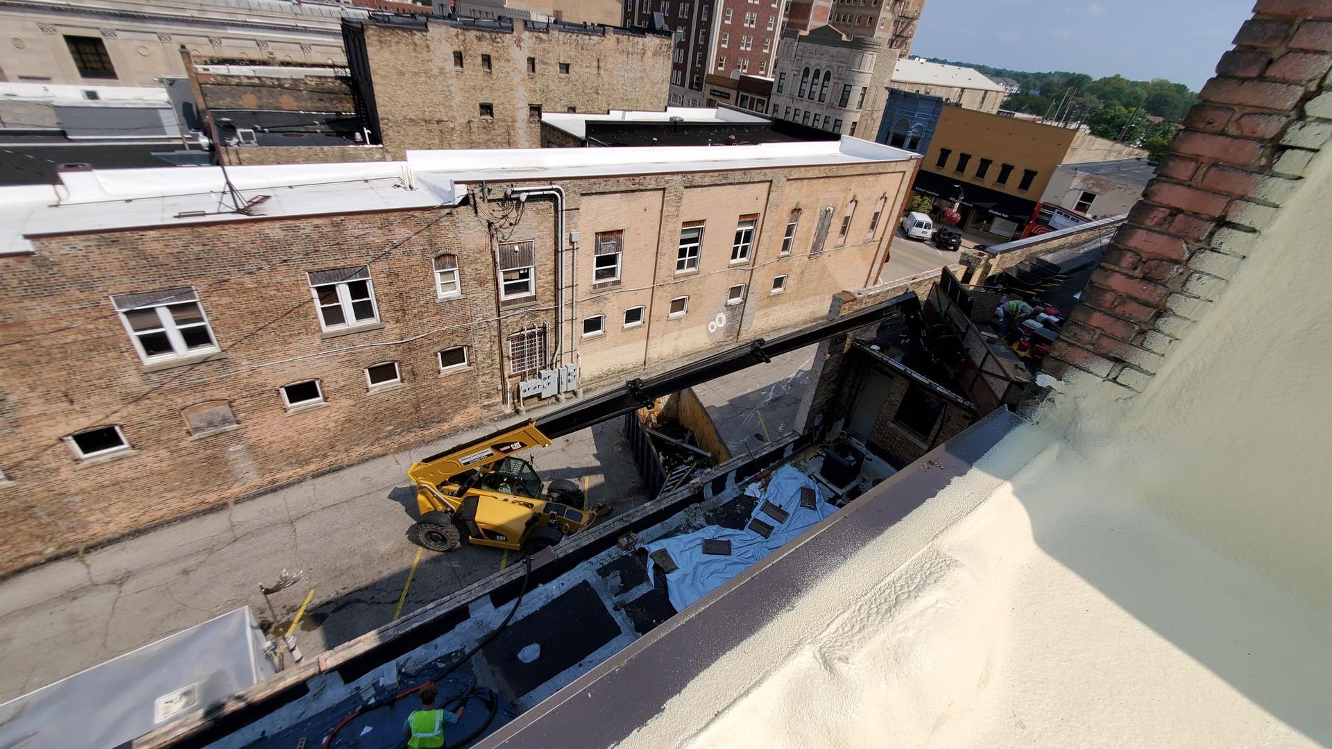 An aerial view of a city street with buildings and a yellow crane.