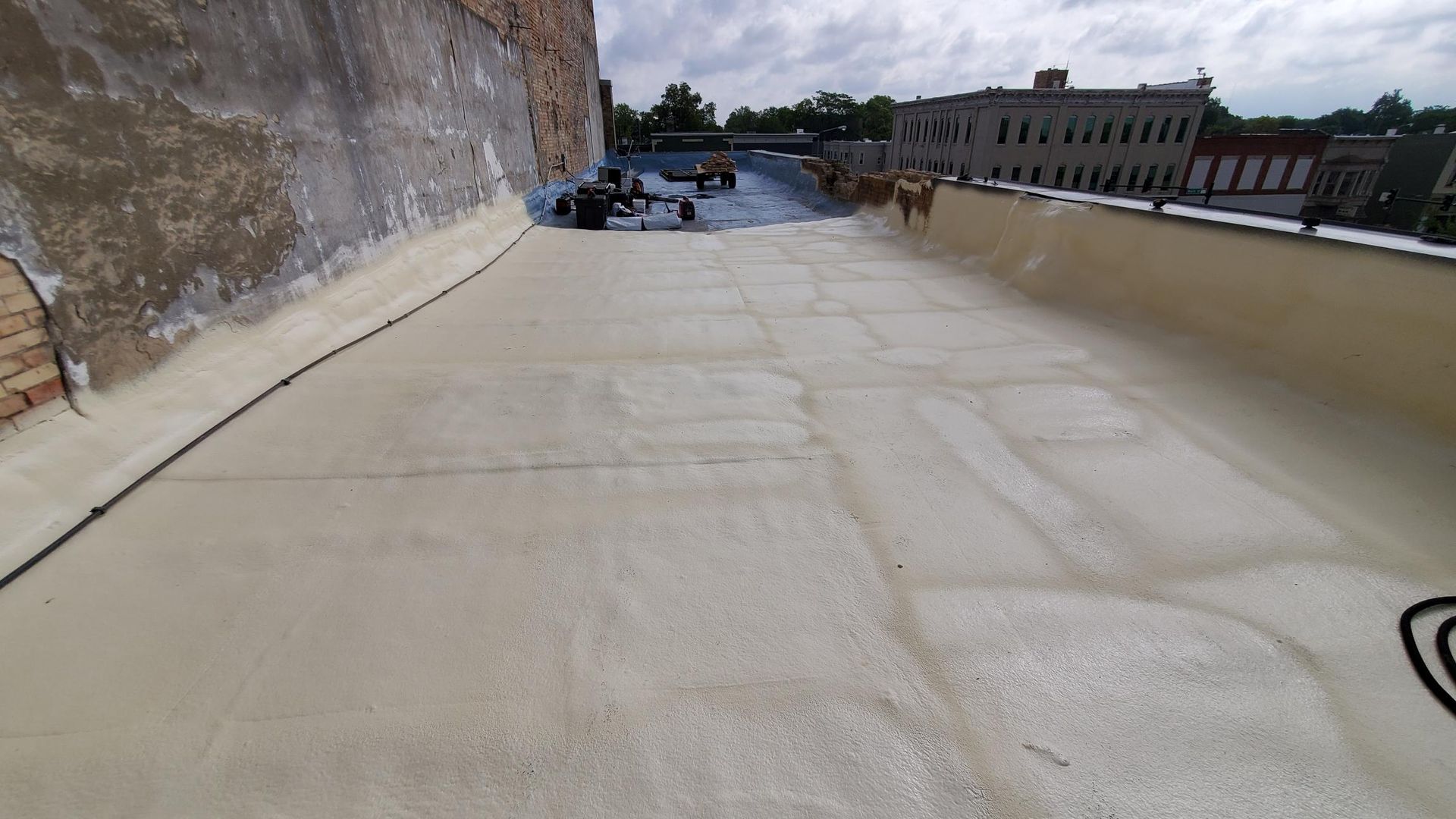 A roof with a lot of foam on it and a building in the background.