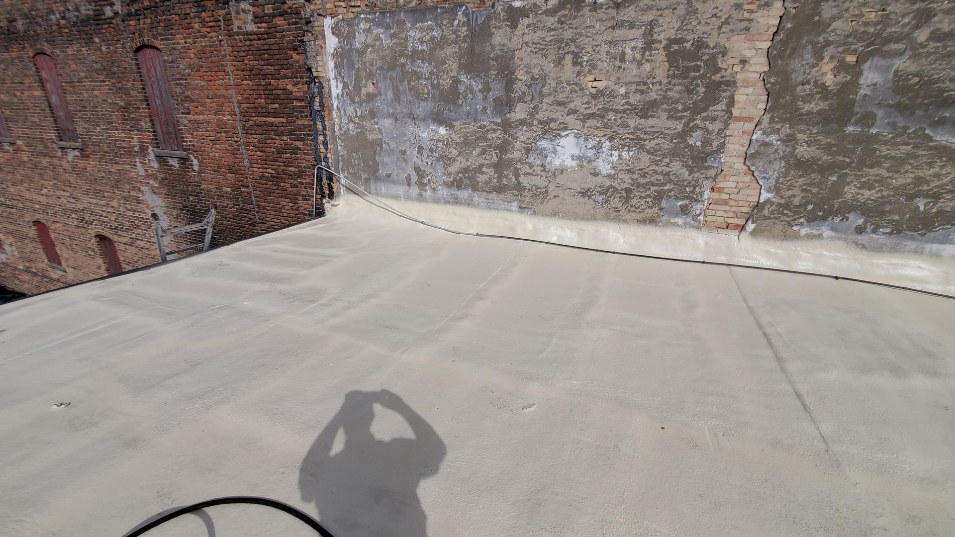 A person is taking a picture of their shadow on the ground.