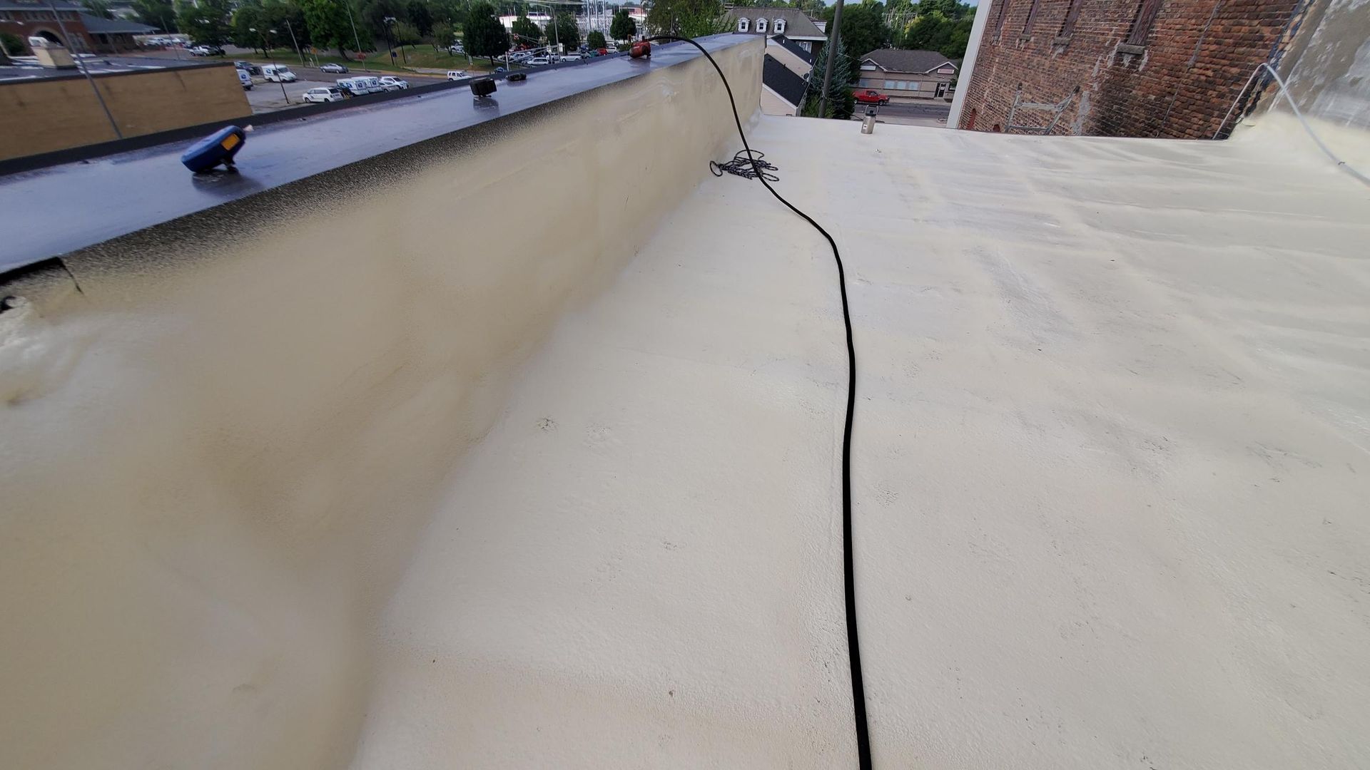 A person is standing on top of a white roof.