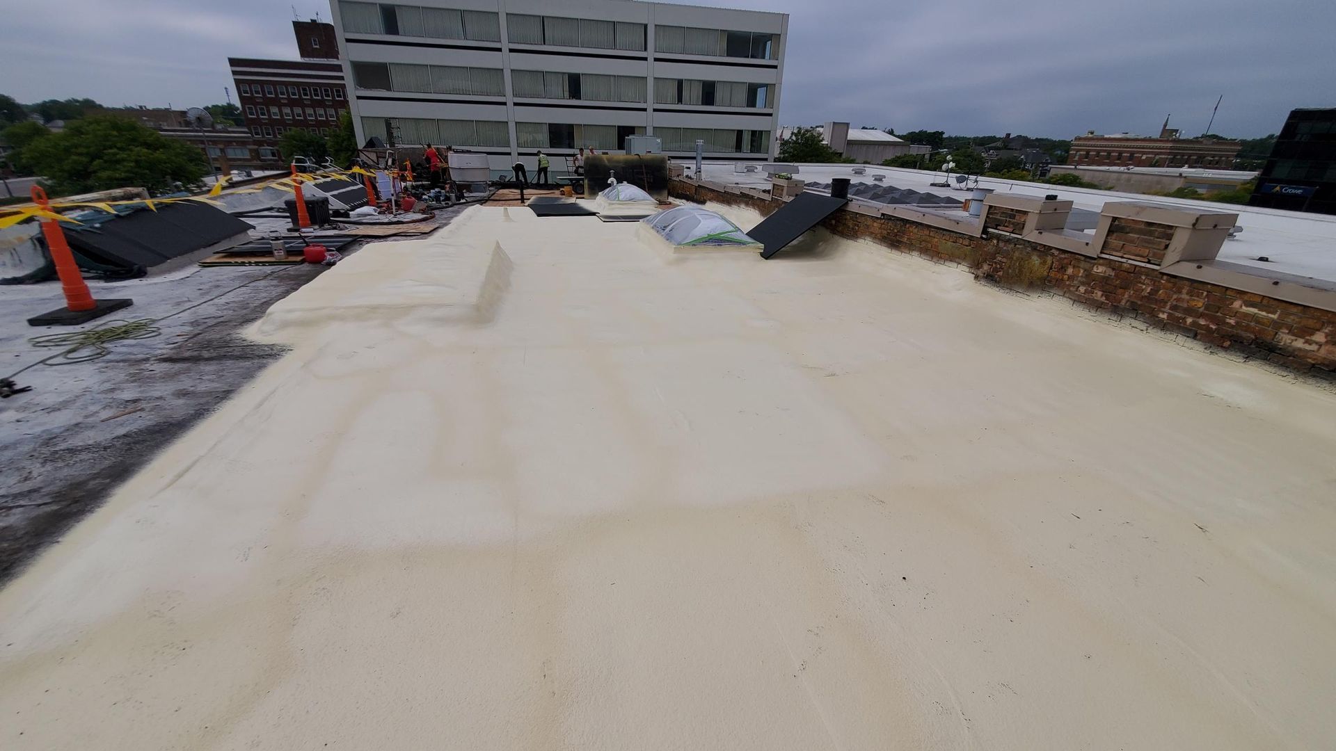 A roof with a lot of foam on it and a building in the background.