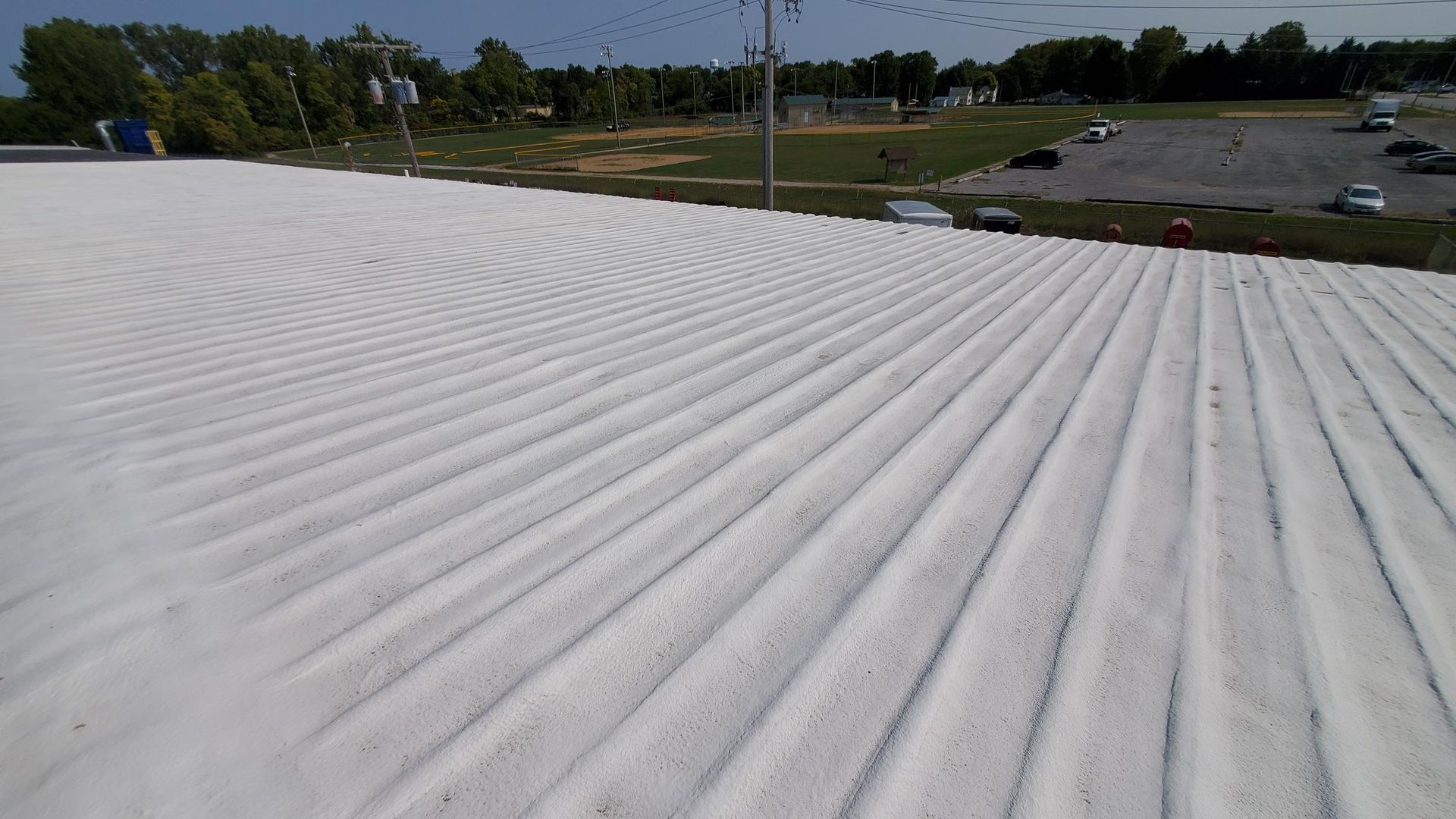 A white roof with a parking lot in the background.