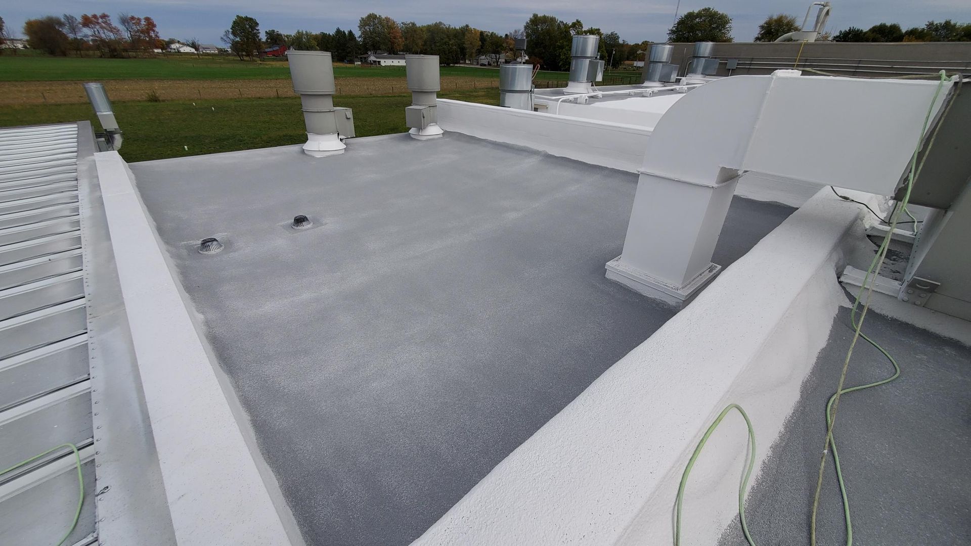 A white roof with a lot of vents on it.