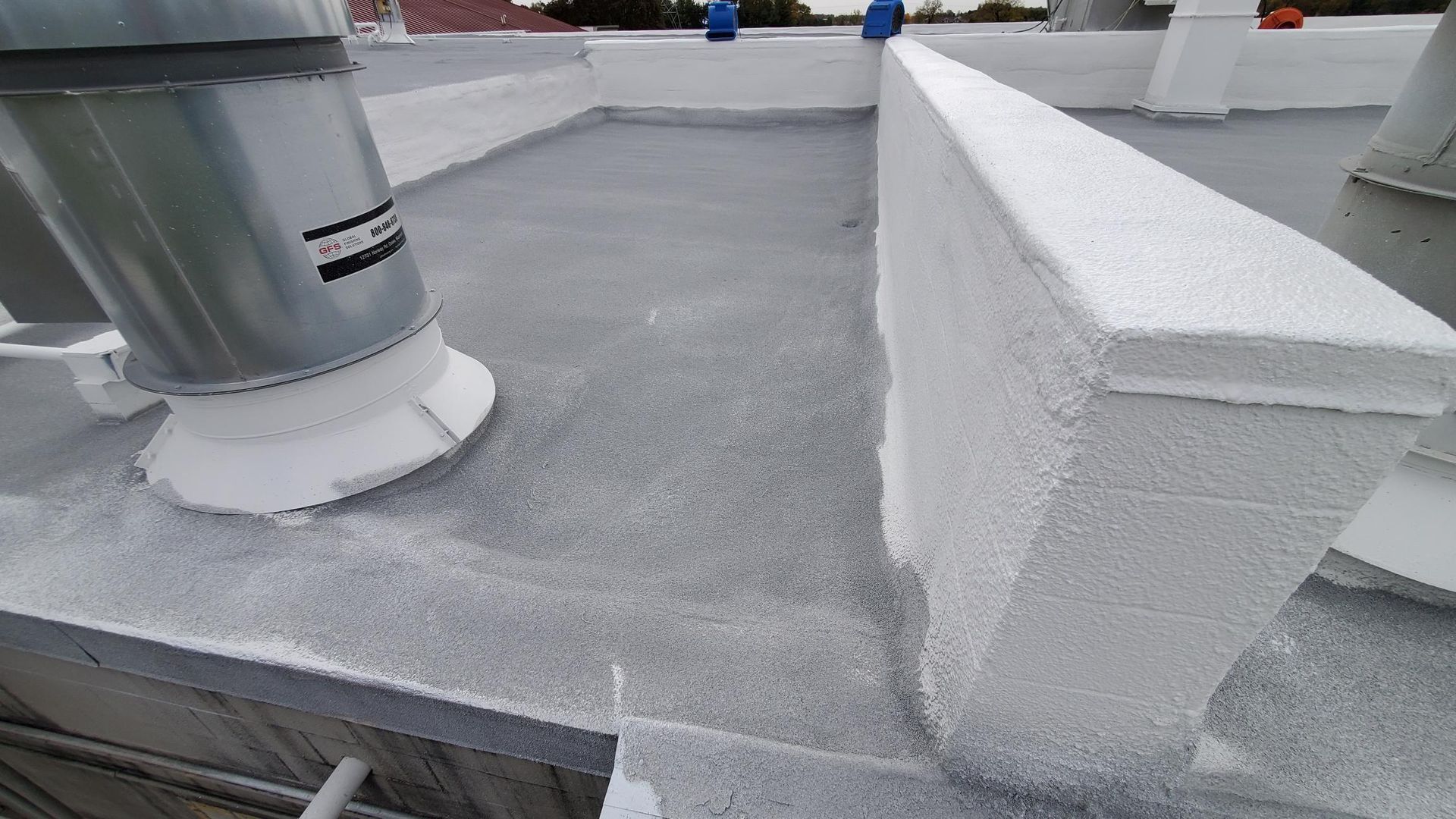 A close up of a roof with a chimney on it.