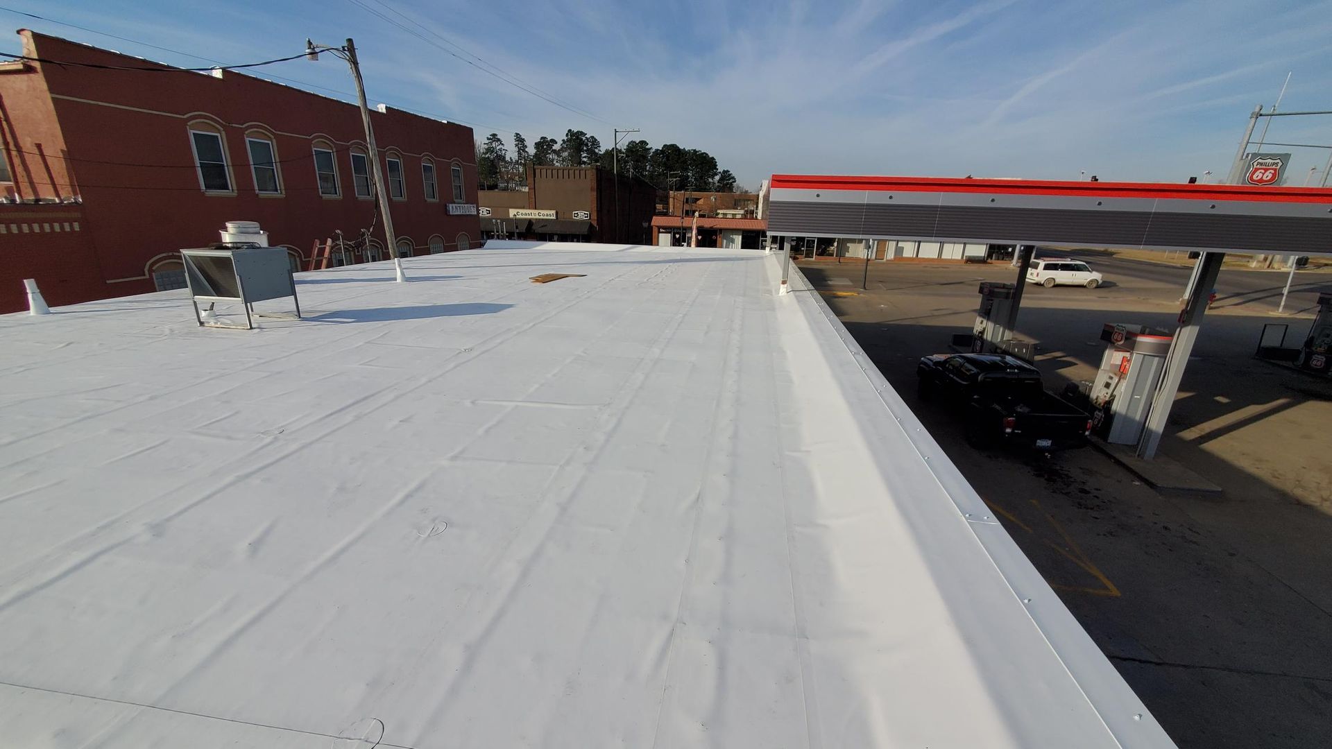 A white roof with a gas station in the background