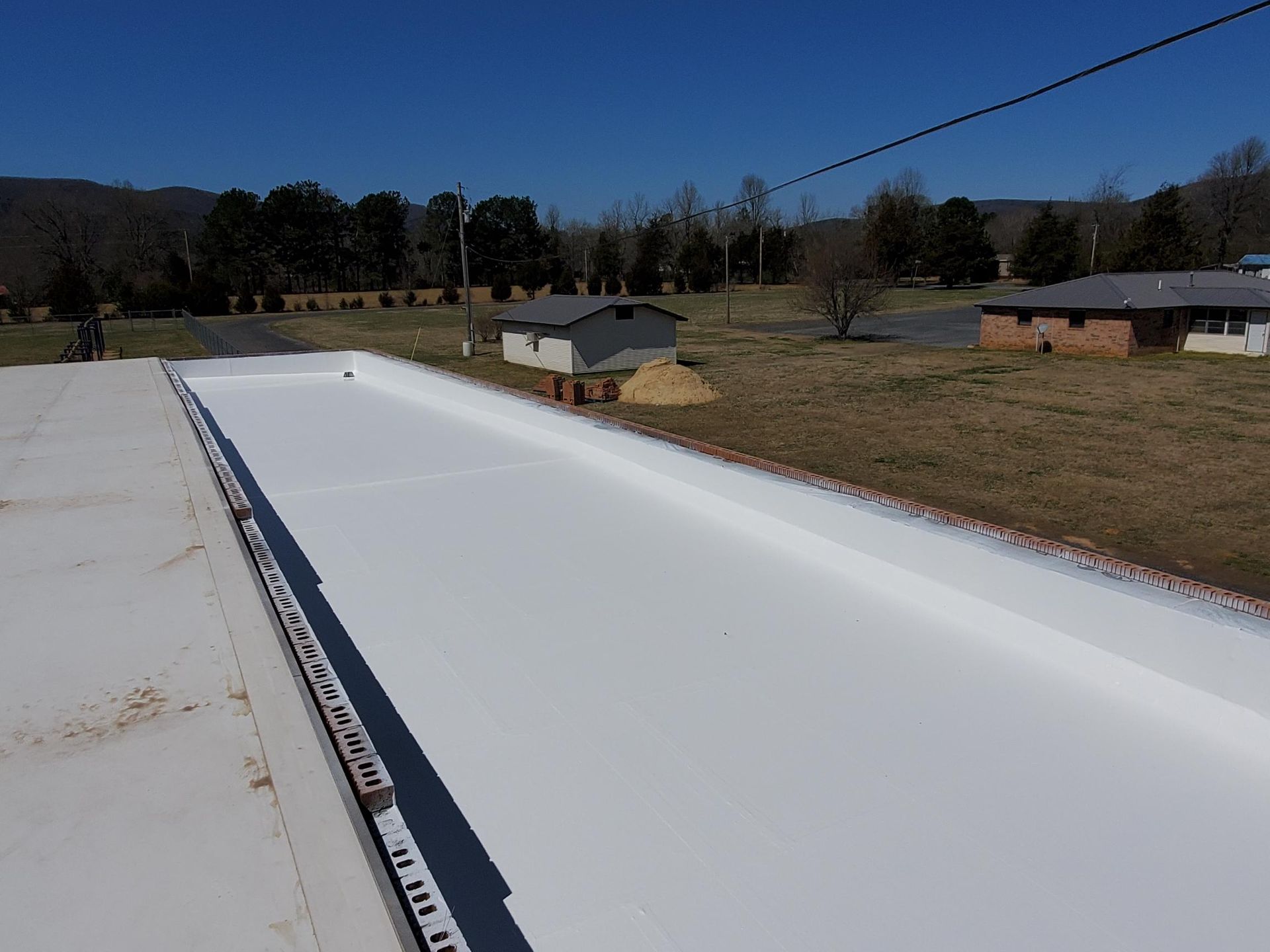 A white roof with a few houses in the background