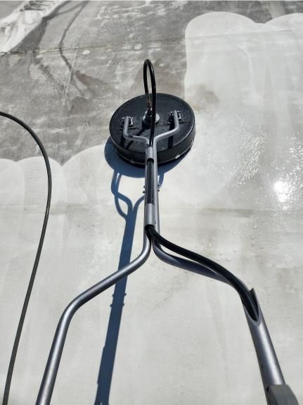 A vacuum cleaner is being used to clean a concrete floor