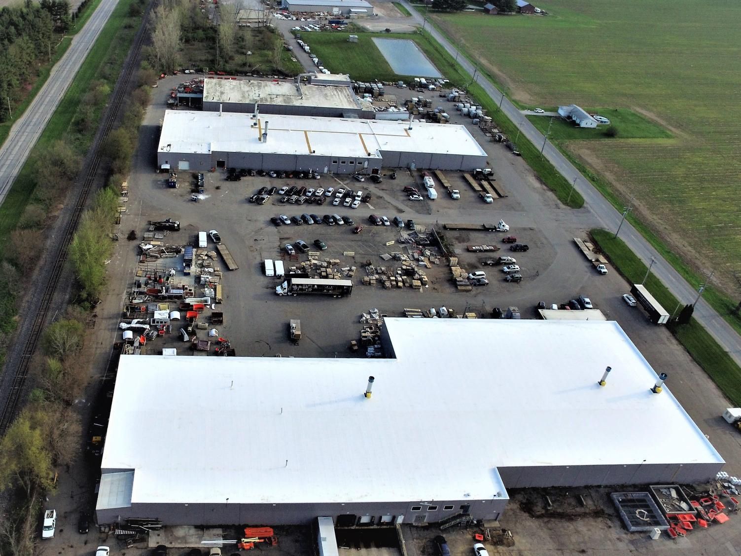 An aerial view of a warehouse with a white roof