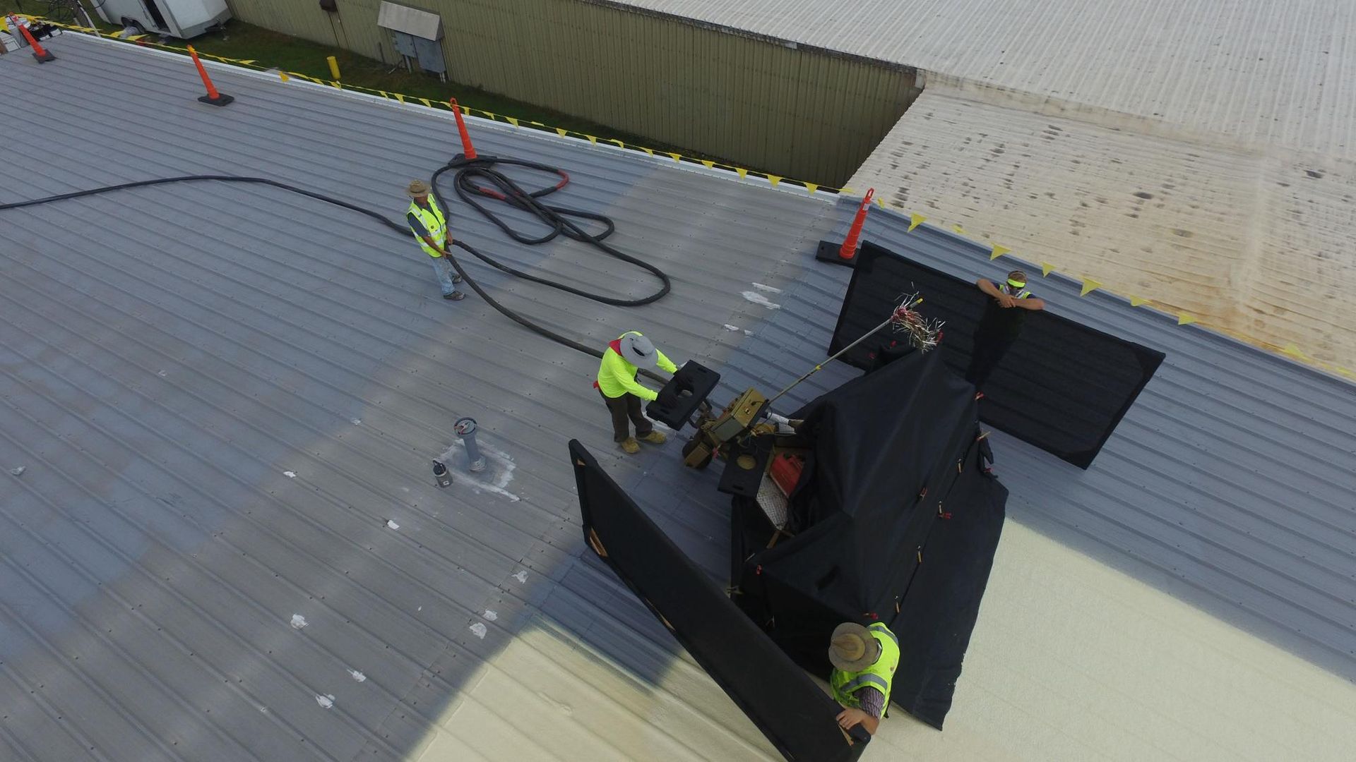 A group of construction workers are working on the roof of a building.
