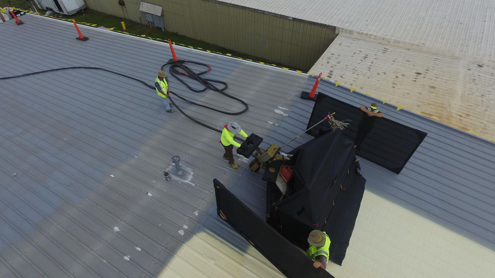A group of construction workers are working on a roof.