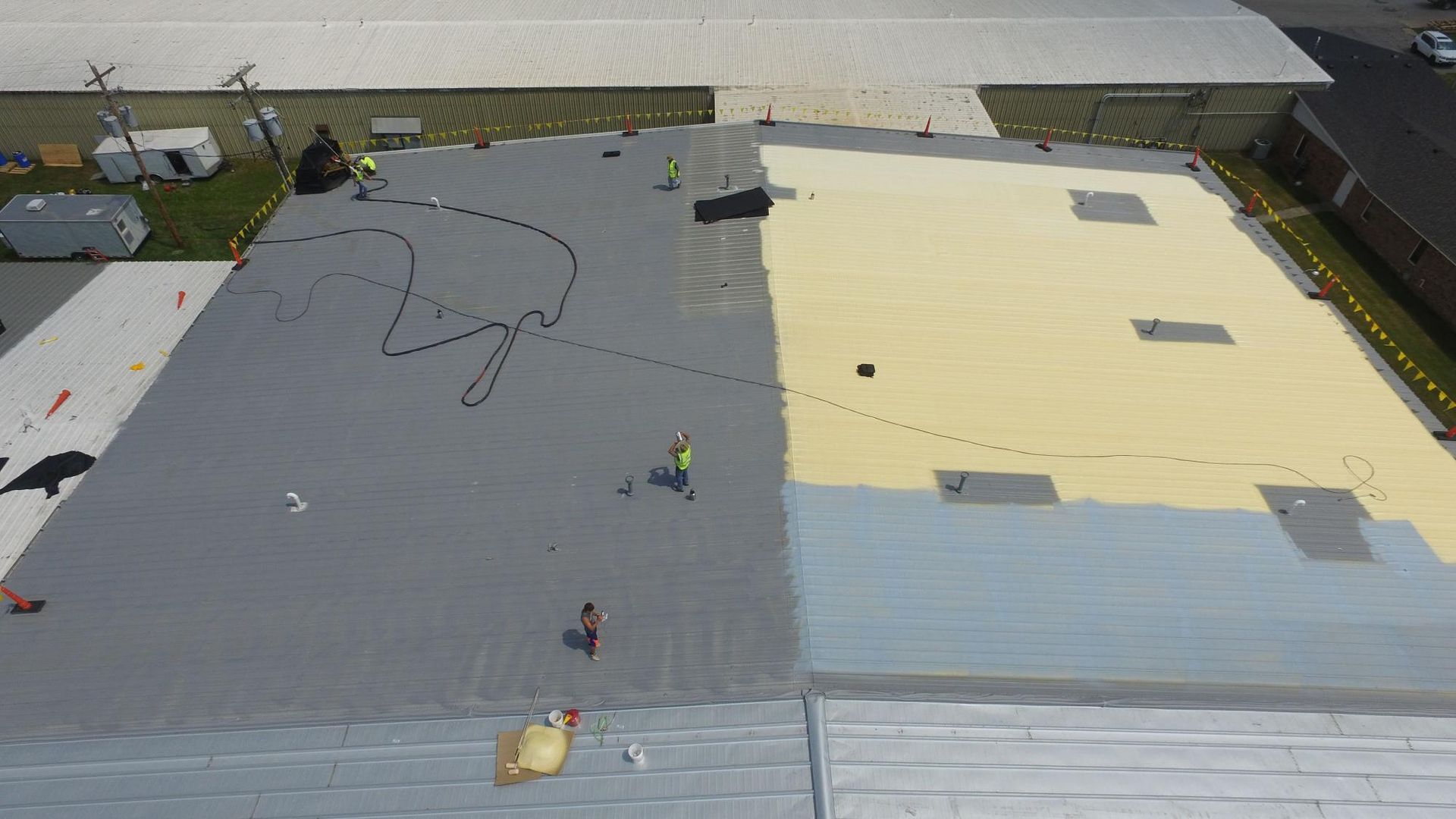 An aerial view of a roof being painted.