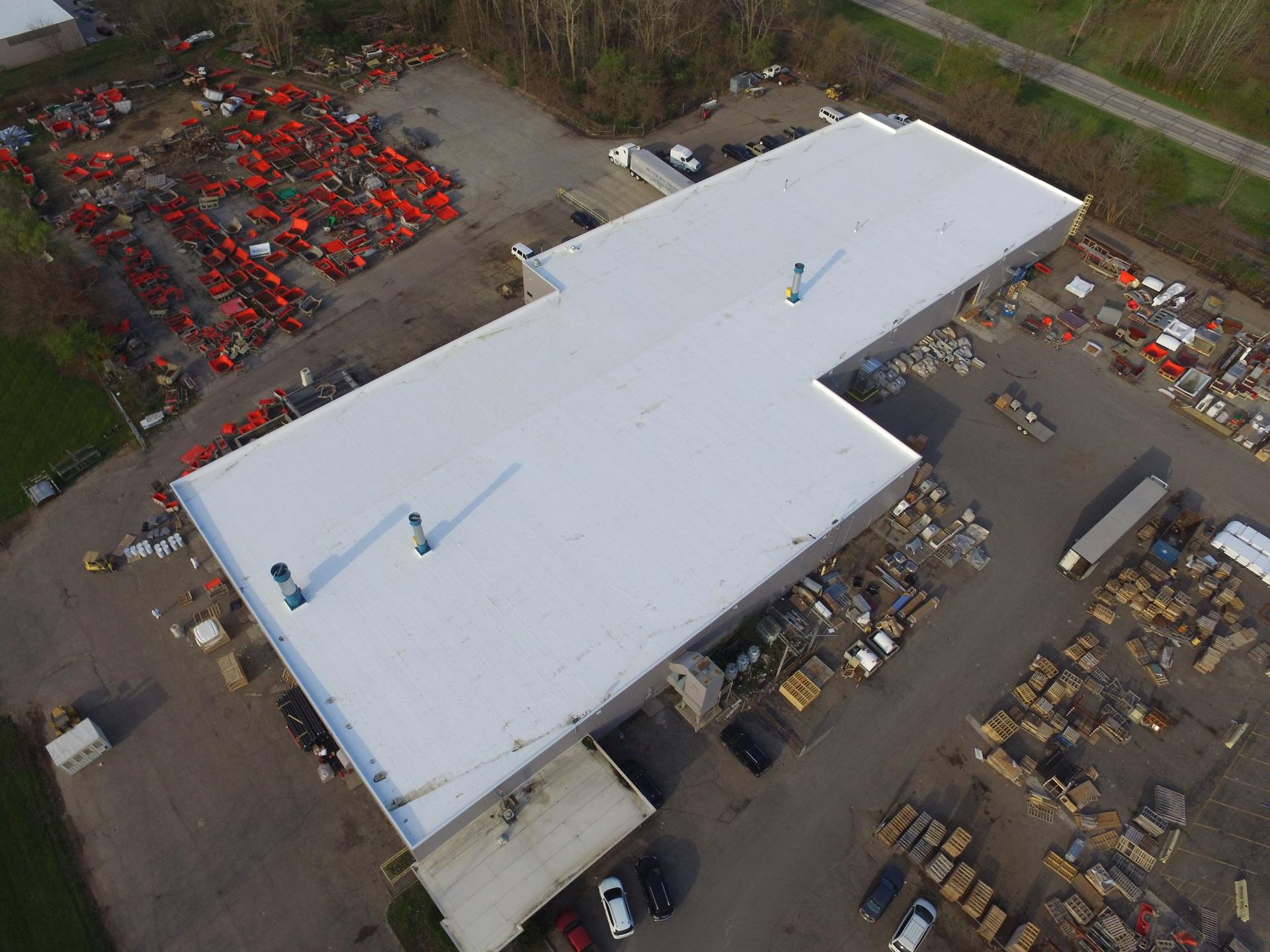 An aerial view of a large building with a white roof.
