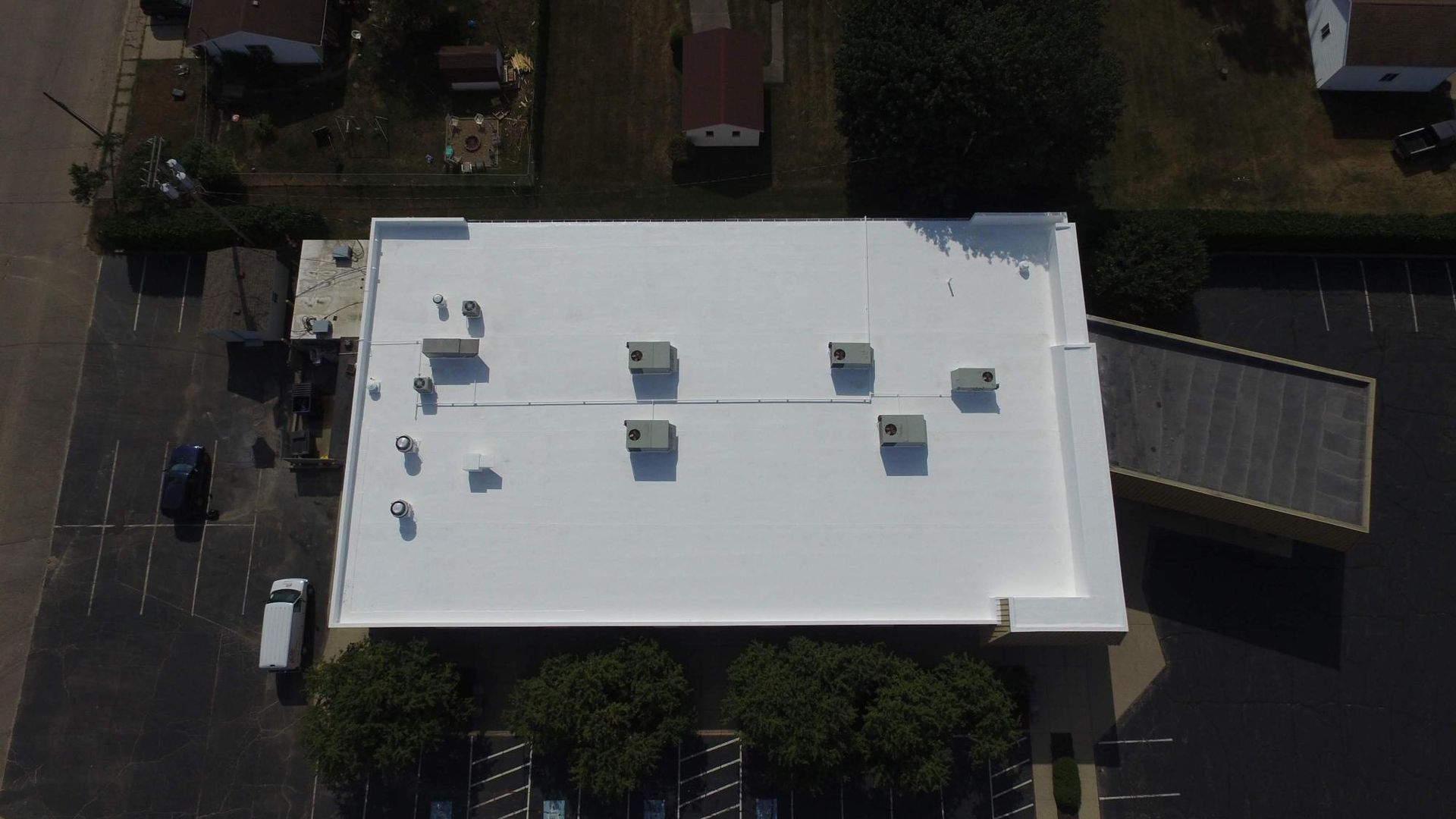 An aerial view of a building with a white roof.