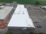 An aerial view of a large building with a white roof.