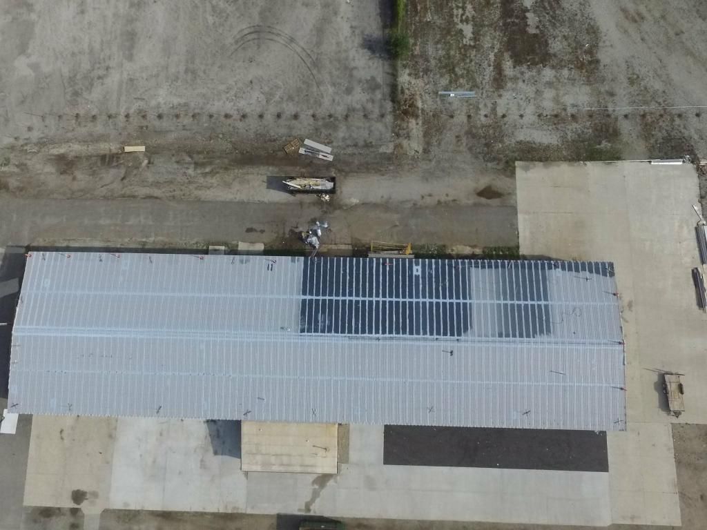 An aerial view of a building with solar panels on the roof.