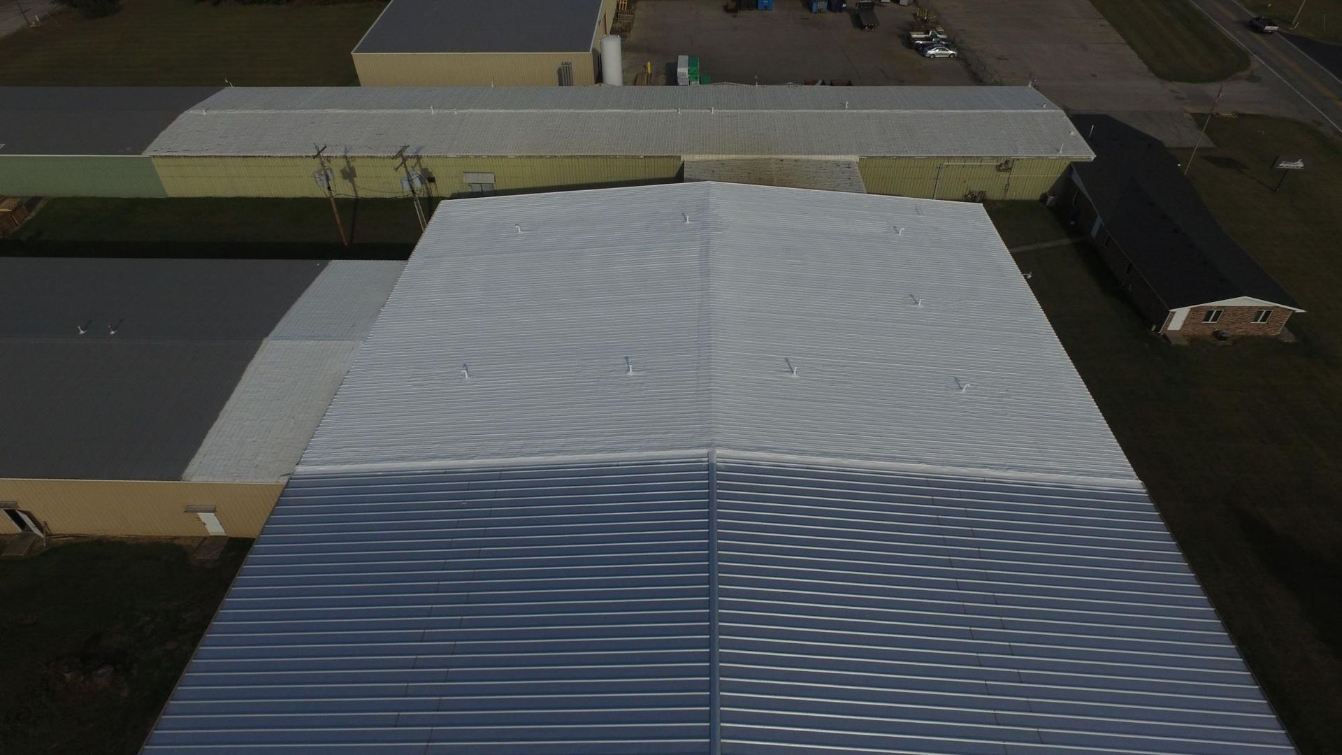An aerial view of a large building with a gray roof.